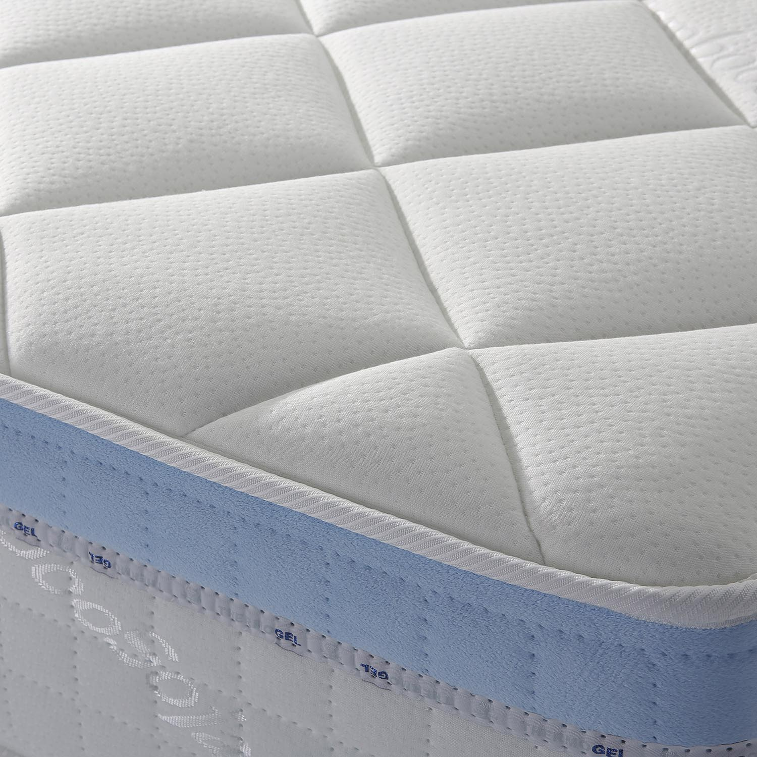 Primer plano de un colchón blanco con detalles azules y superficie acolchada.