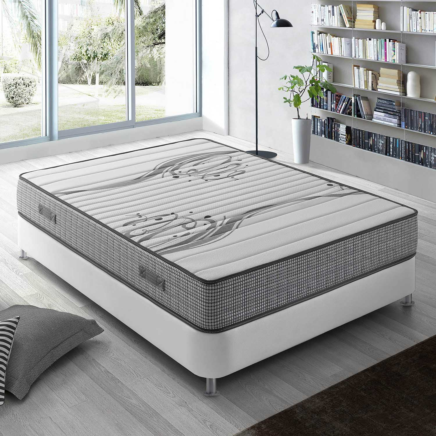 Una cama blanca con funda de colchón estampada, estantería al fondo.