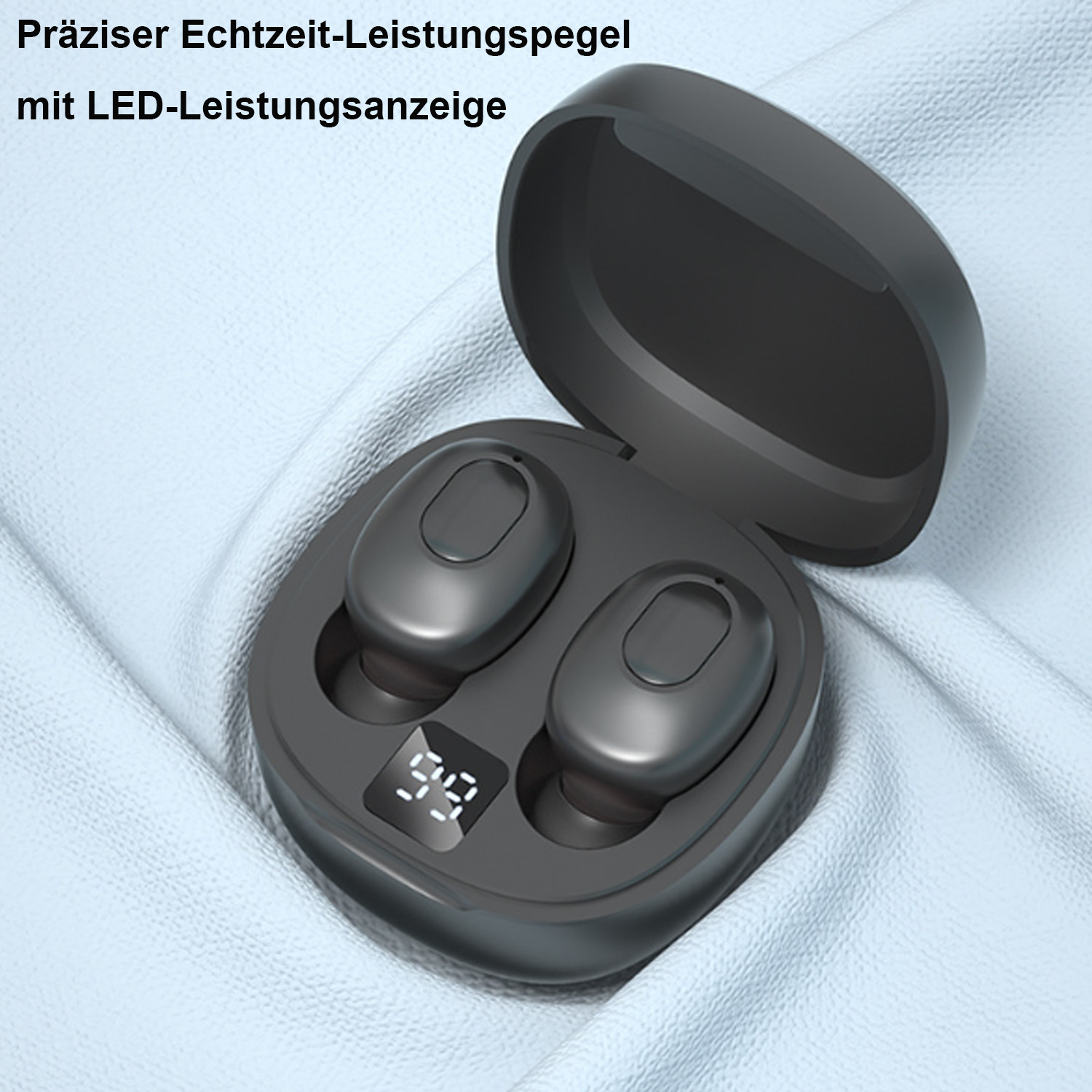 Schwarze kabellose Ohrhörer in einer Ladehülle mit digitaler Anzeige auf hellblauem Stoff.