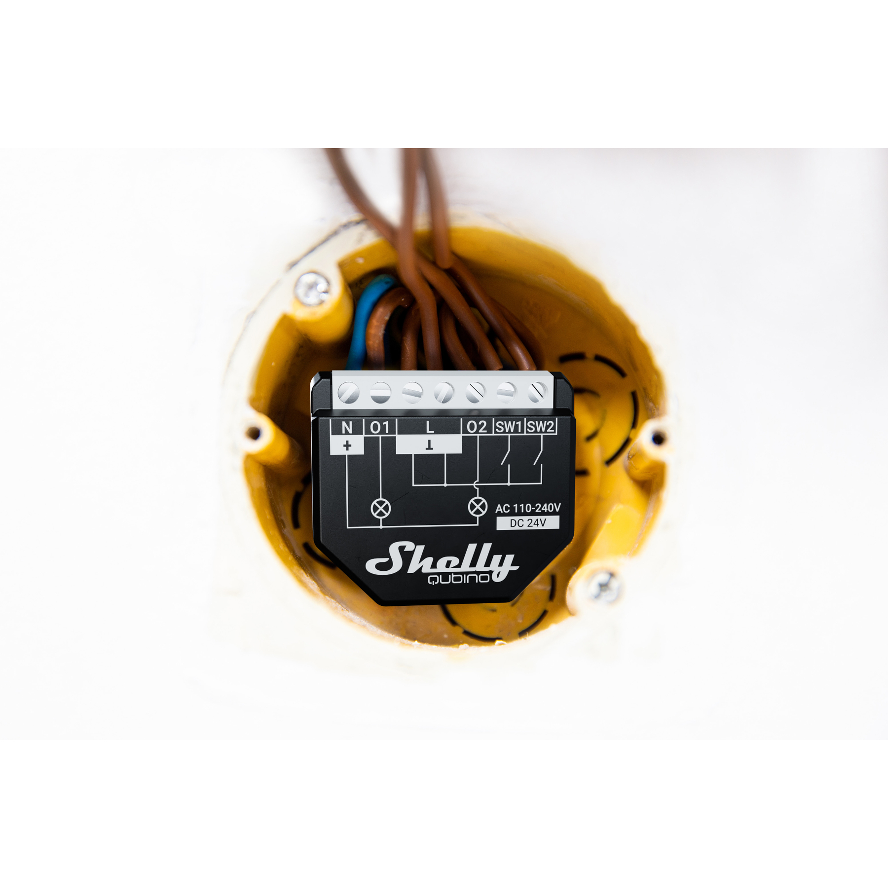 Moduł inteligentnego domu Shelly Qubino w żółtej puszce instalacyjnej z wieloma przewodami.
