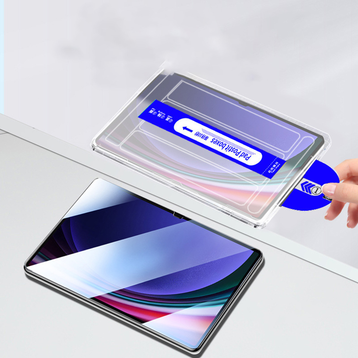 Una mano stacca una linguetta blu da una pellicola protettiva per tablet.