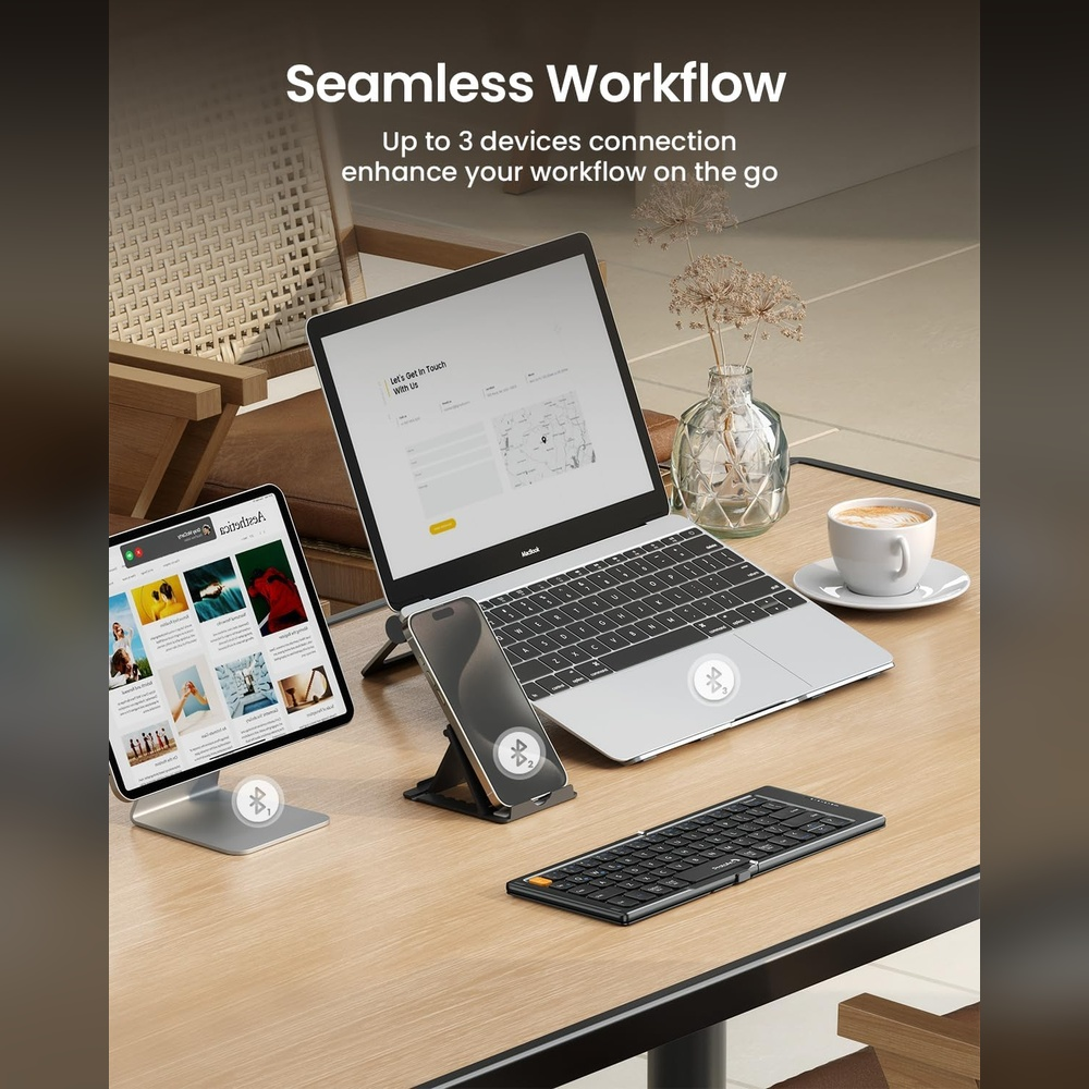 Een laptop, tablet, smartphone en opvouwbaar toetsenbord op een bureau.