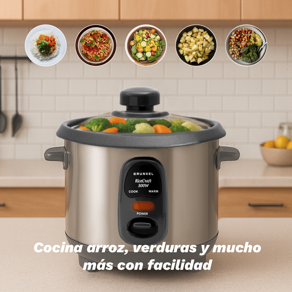 Una arrocera plateada con verduras al vapor y platos de comida.