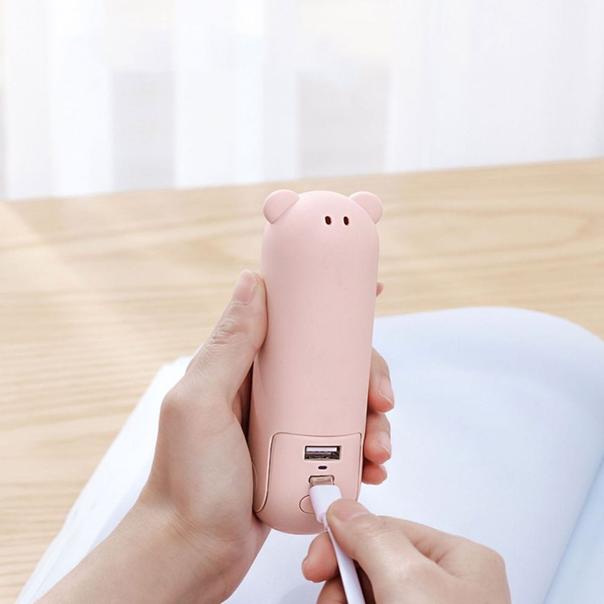 Eine rosafarbene Powerbank in Bärenform wird aufgeladen.