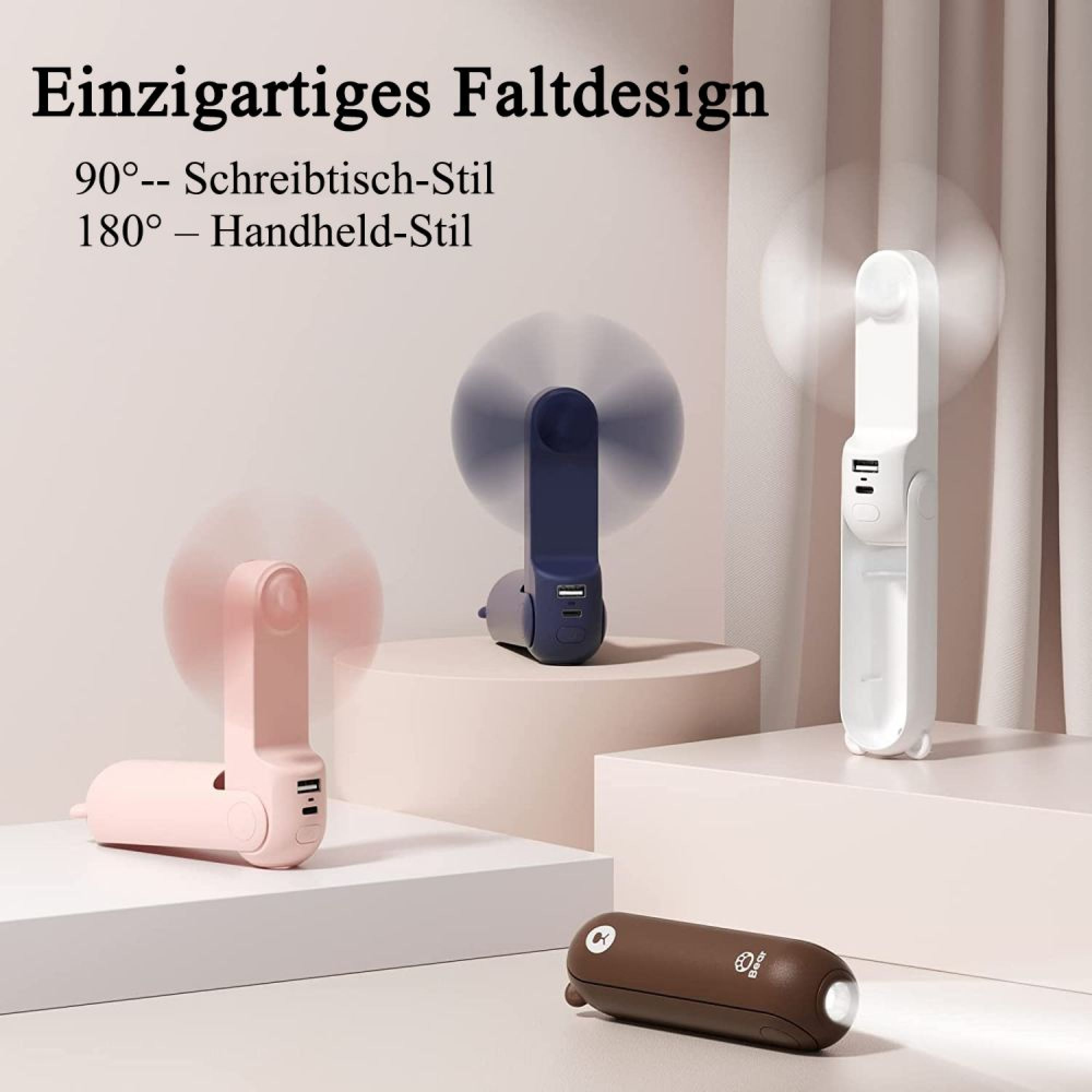 Drei faltbare Mini-Ventilatoren in Rosa, Dunkelblau und Weiß, mit USB-Anschluss.