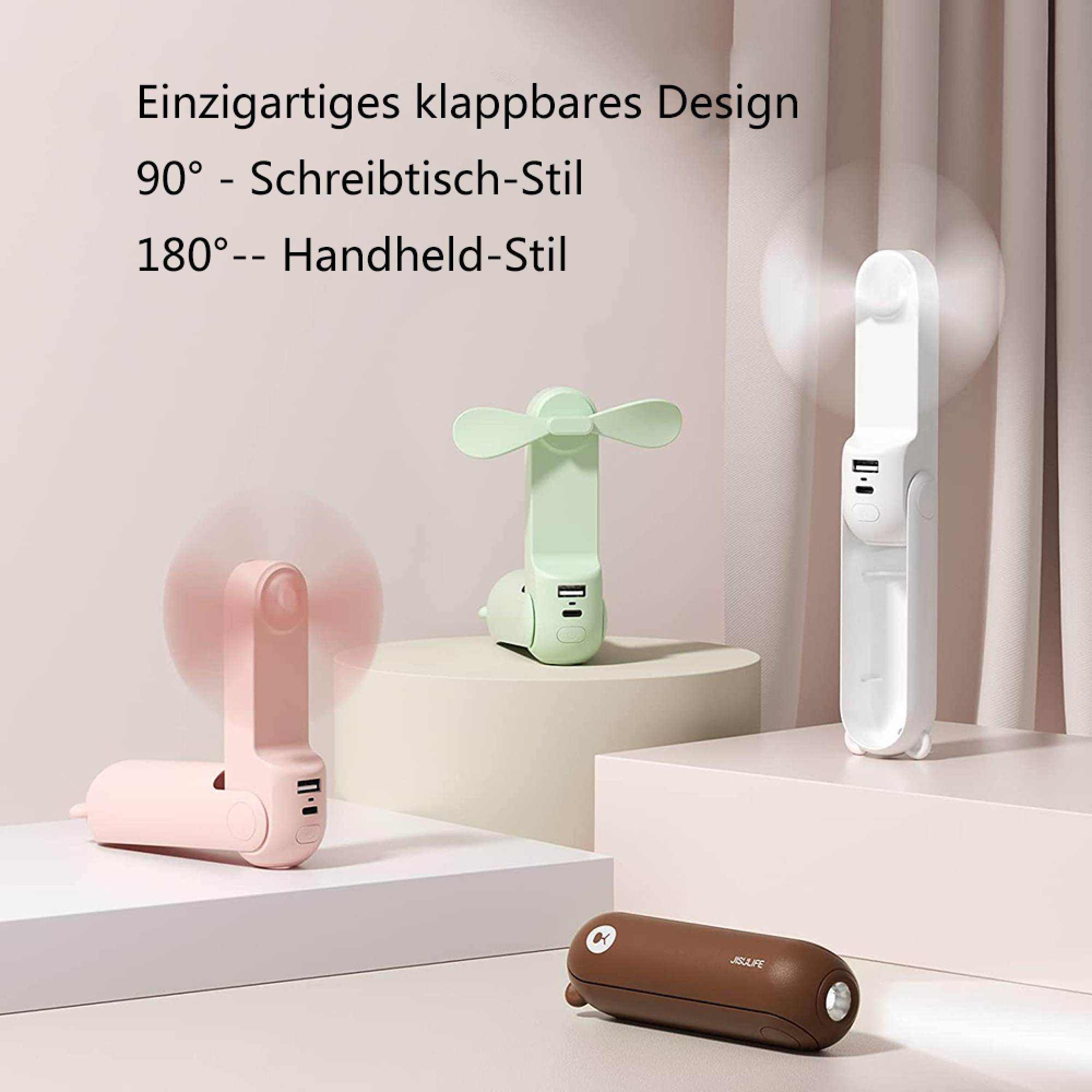 Drei faltbare Lüfter in Pink, Grün und Weiß. Ein brauner Koffer liegt vorne.