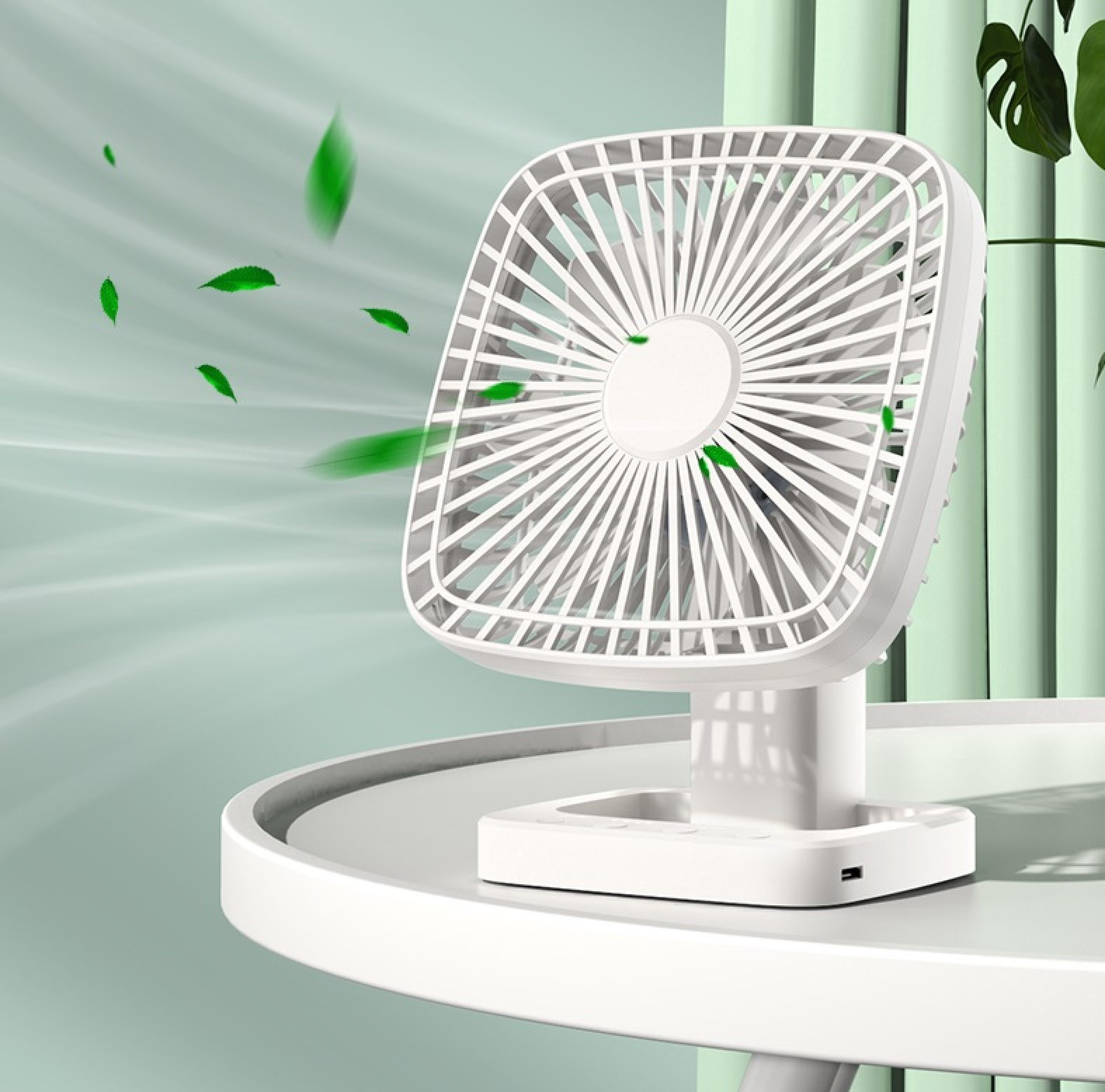 Ein weißer Tischventilator mit grünen Blättern, die hindurchgeweht werden.