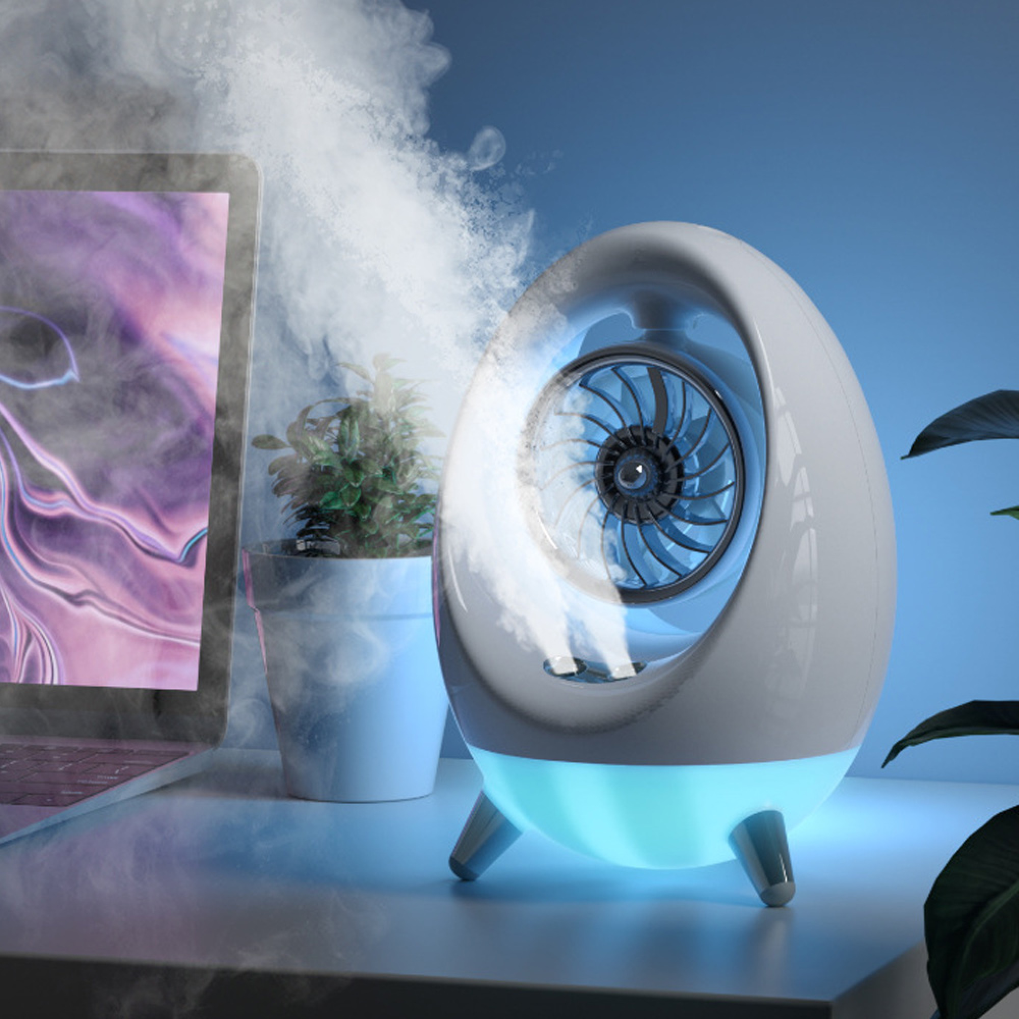 Ein weißes, eiförmiges Gerät mit blauem Ventilator stößt Nebel neben Laptop und Pflanze aus.