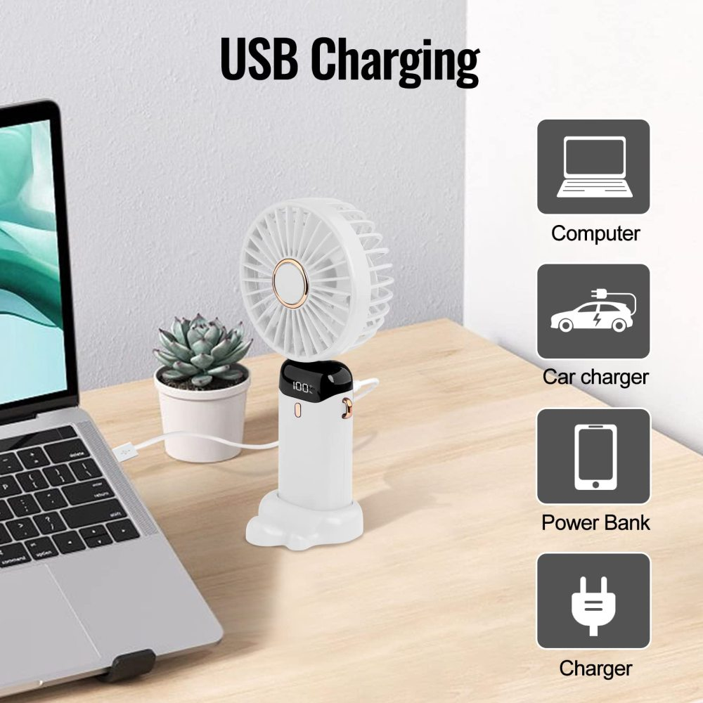Ein weißer USB-Ventilator mit Ladestandanzeige steht neben einem Laptop und einer Pflanze.