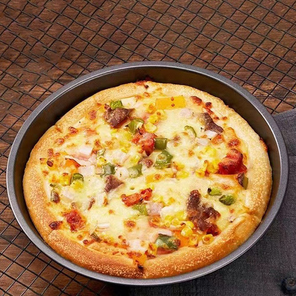 Eine runde Pizza mit Belägen wie Mais, Paprika und Fleisch in einer runden Form.