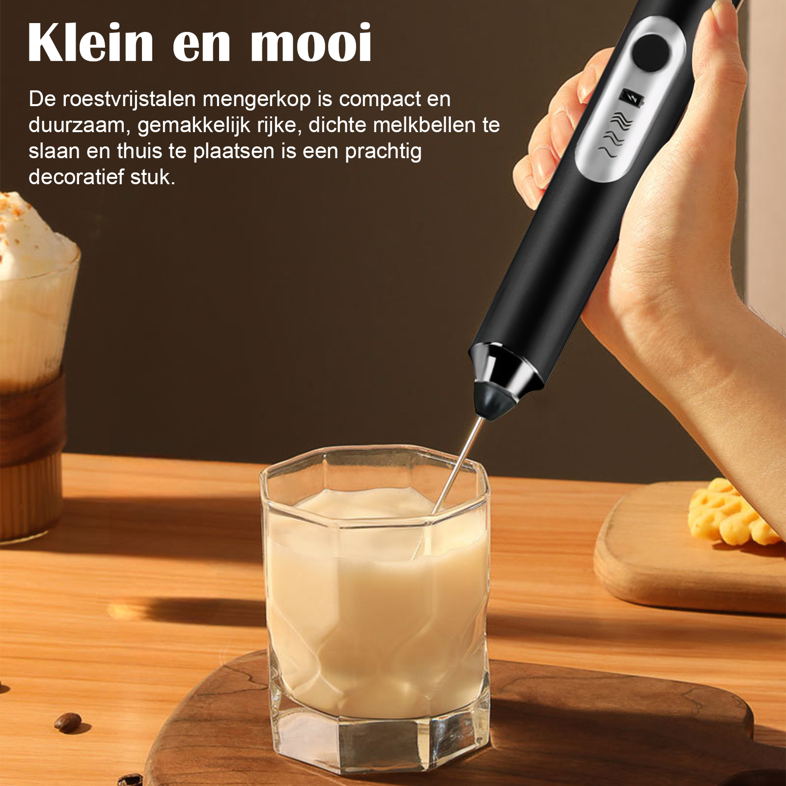 Eine Hand hält einen schwarzen Milchaufschäumer über einem Glas Milch.