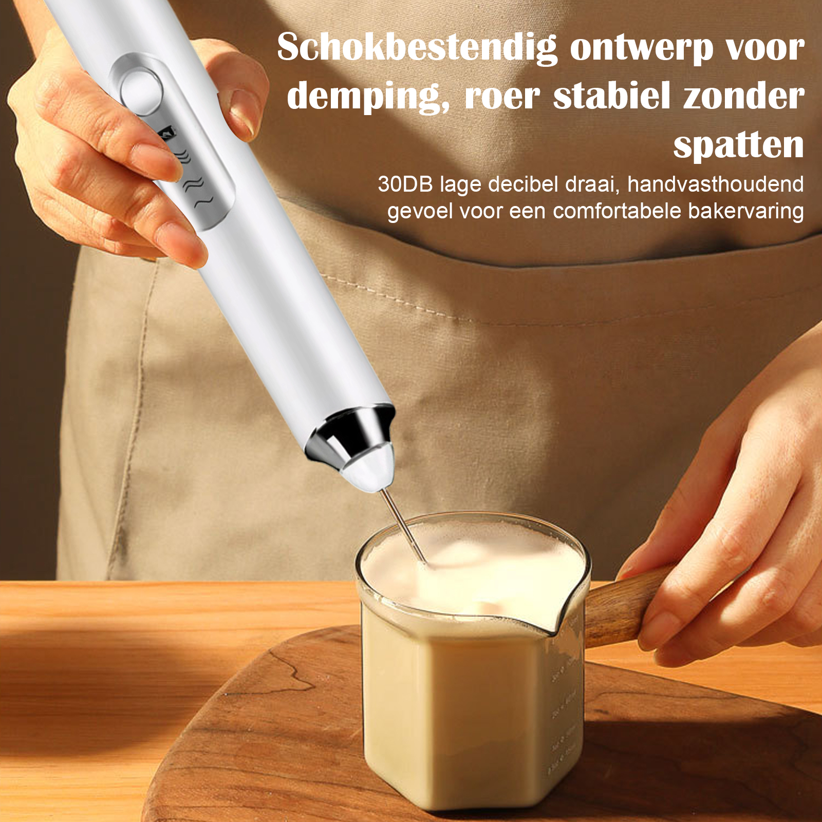 Ein weißer elektrischer Milchaufschäumer schlägt cremige Milch in einem Glasbecher auf.