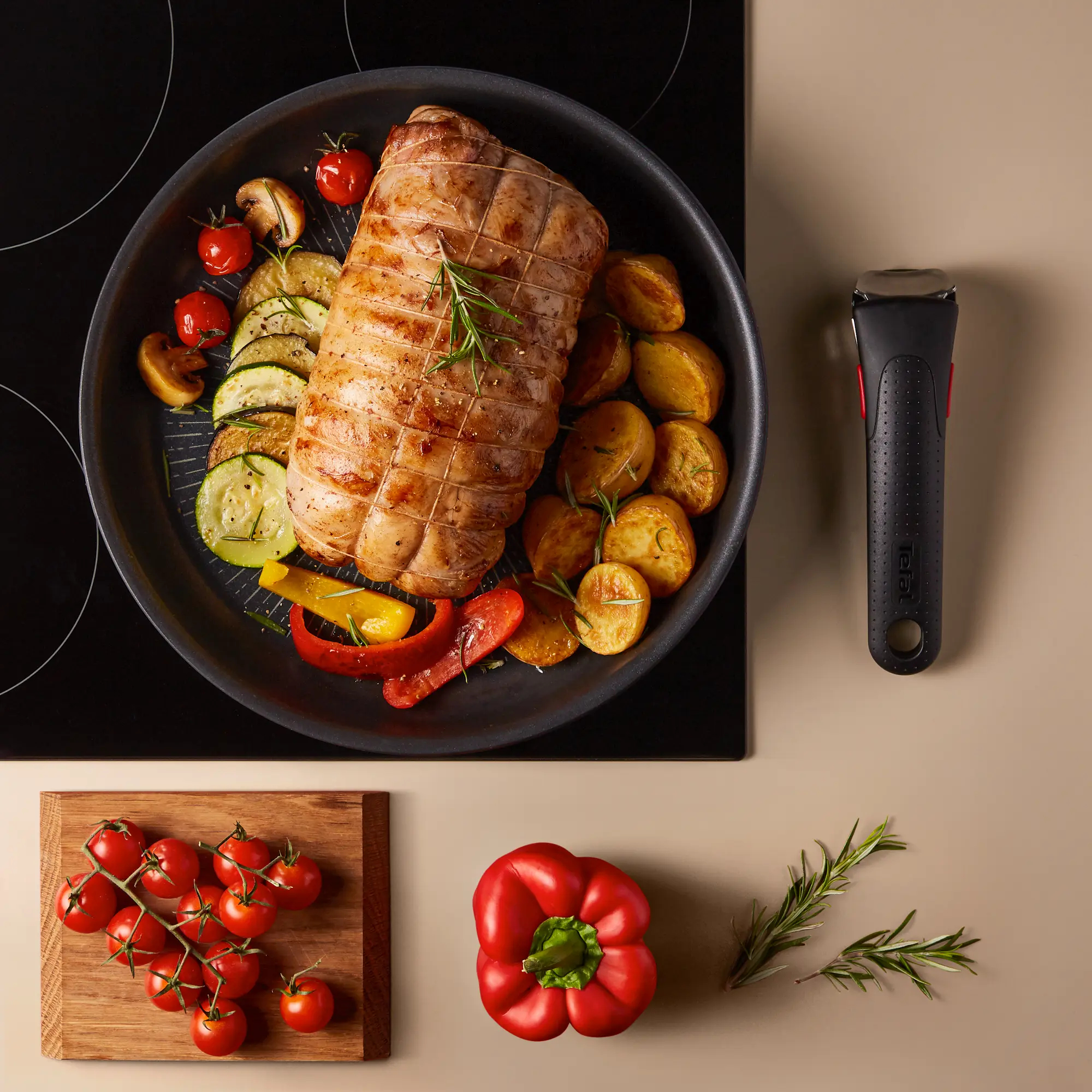 Gebratenes Fleisch mit Kartoffeln, Zucchini, Tomaten und Pilzen in einer Pfanne.