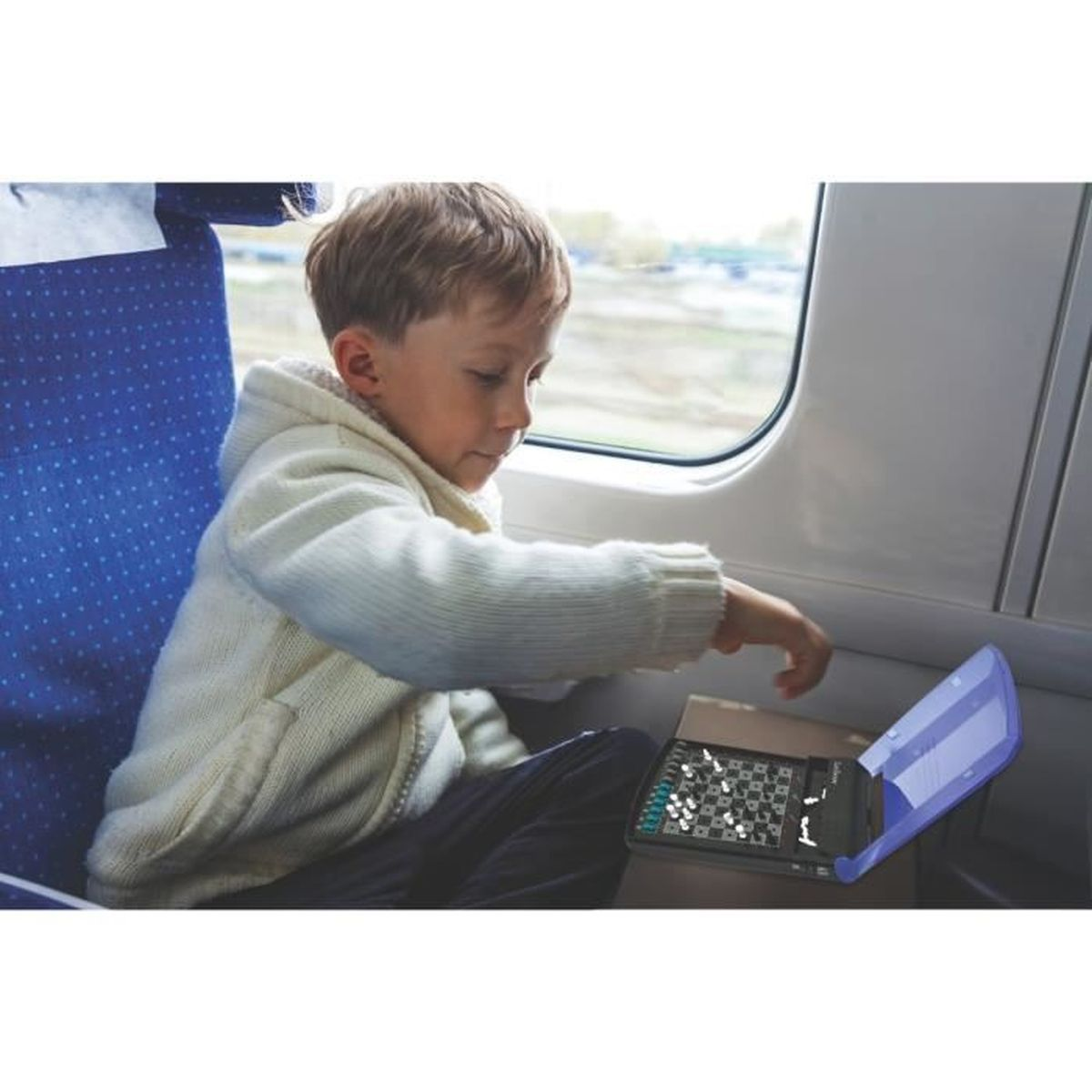 Ragazzo in maglione gioca a scacchi sul treno. Paesaggio fuori dal finestrino.