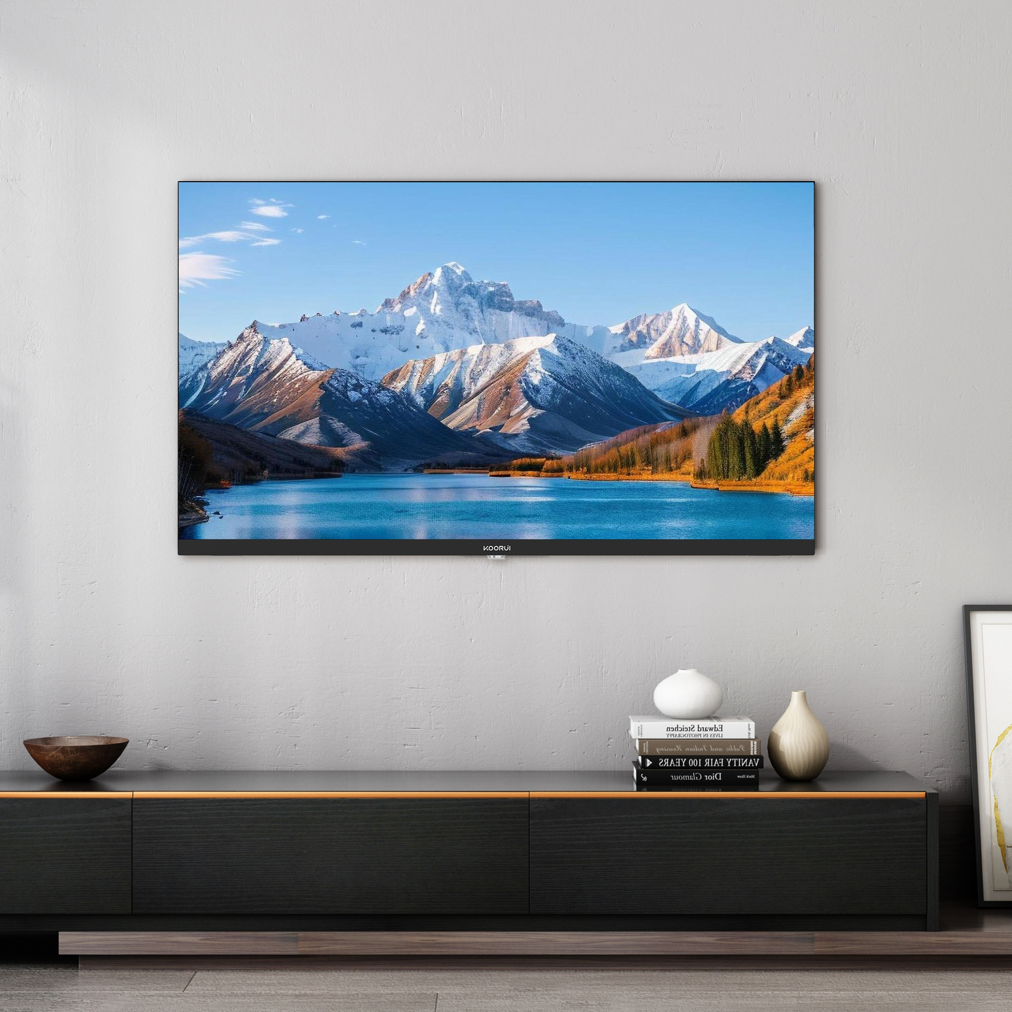 Ein Bergsee mit schneebedeckten Bergen und Herbstbäumen, angezeigt auf einem Fernseher.
