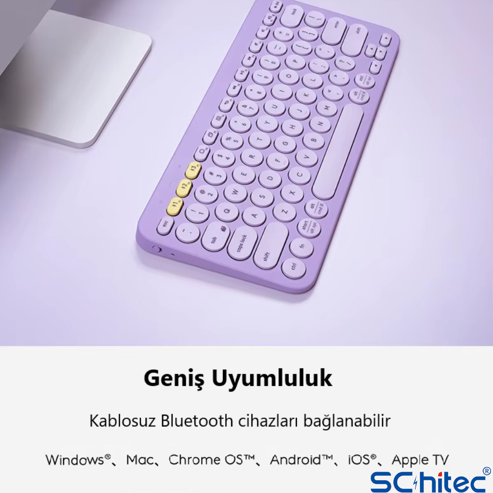 Lavanta rengi klavye, açık mor yüzeydeki beyaz bir nesnenin yanında duruyor.