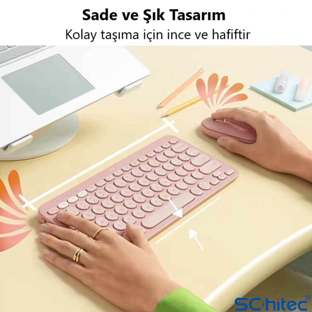Pembe bir klavye ve fare, dizüstü bilgisayarın yanında bej bir masada duruyor.