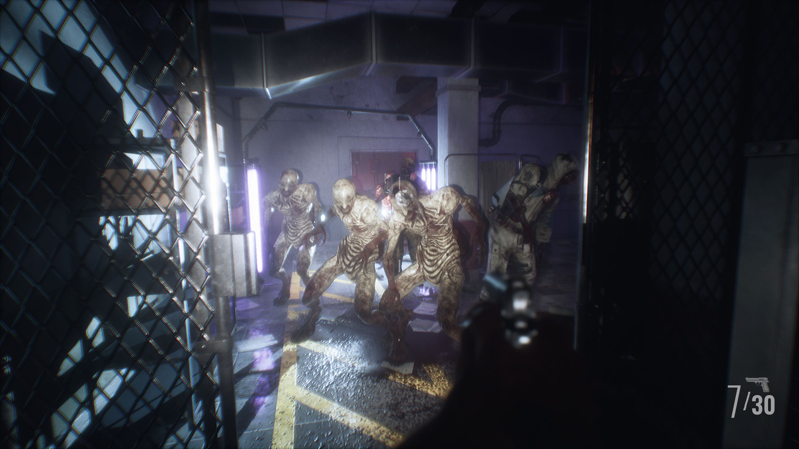 Un gruppo di zombie cammina in un corridoio buio con luci al neon e recinzioni.