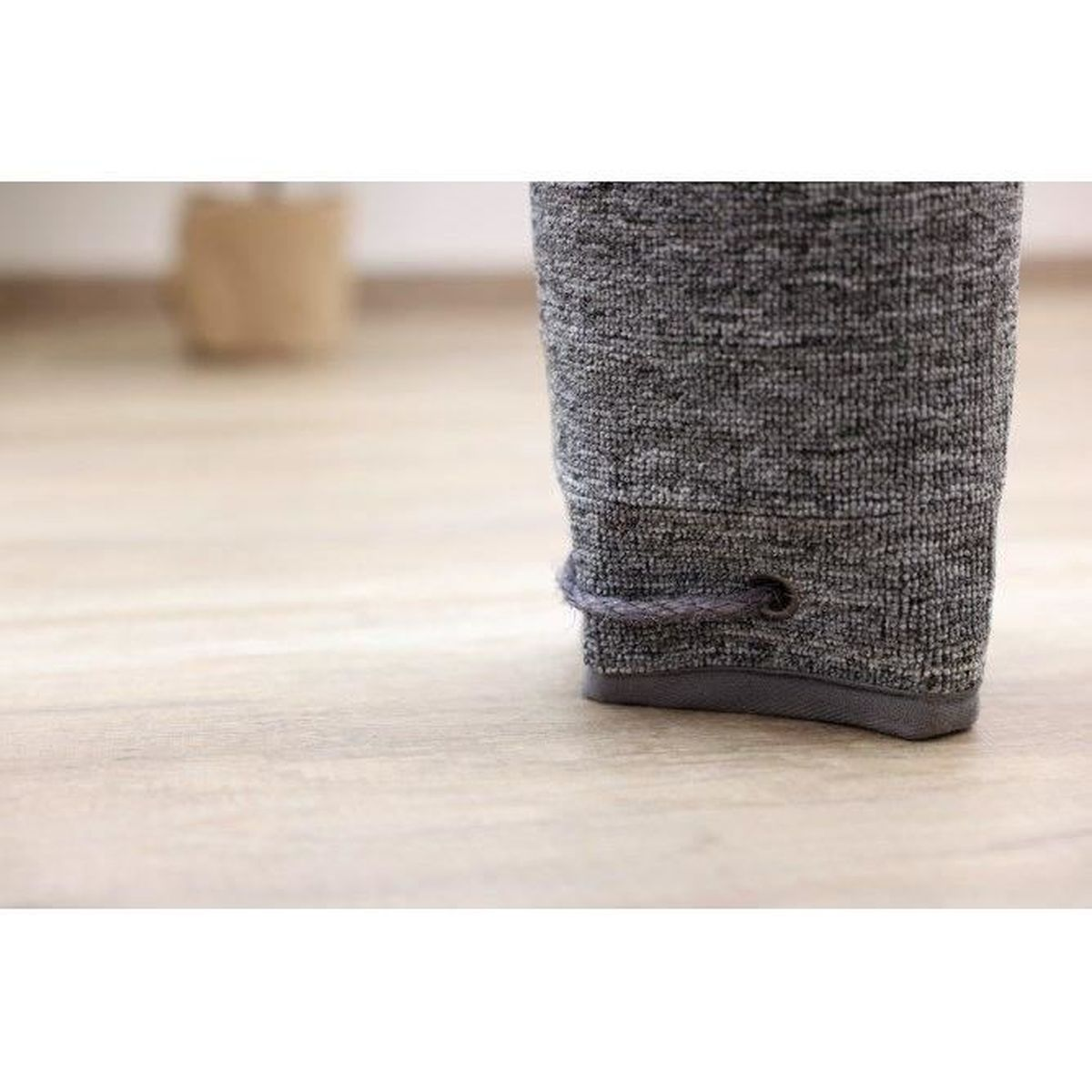 Grauer Stoffschuh mit Kordel auf Holzboden.