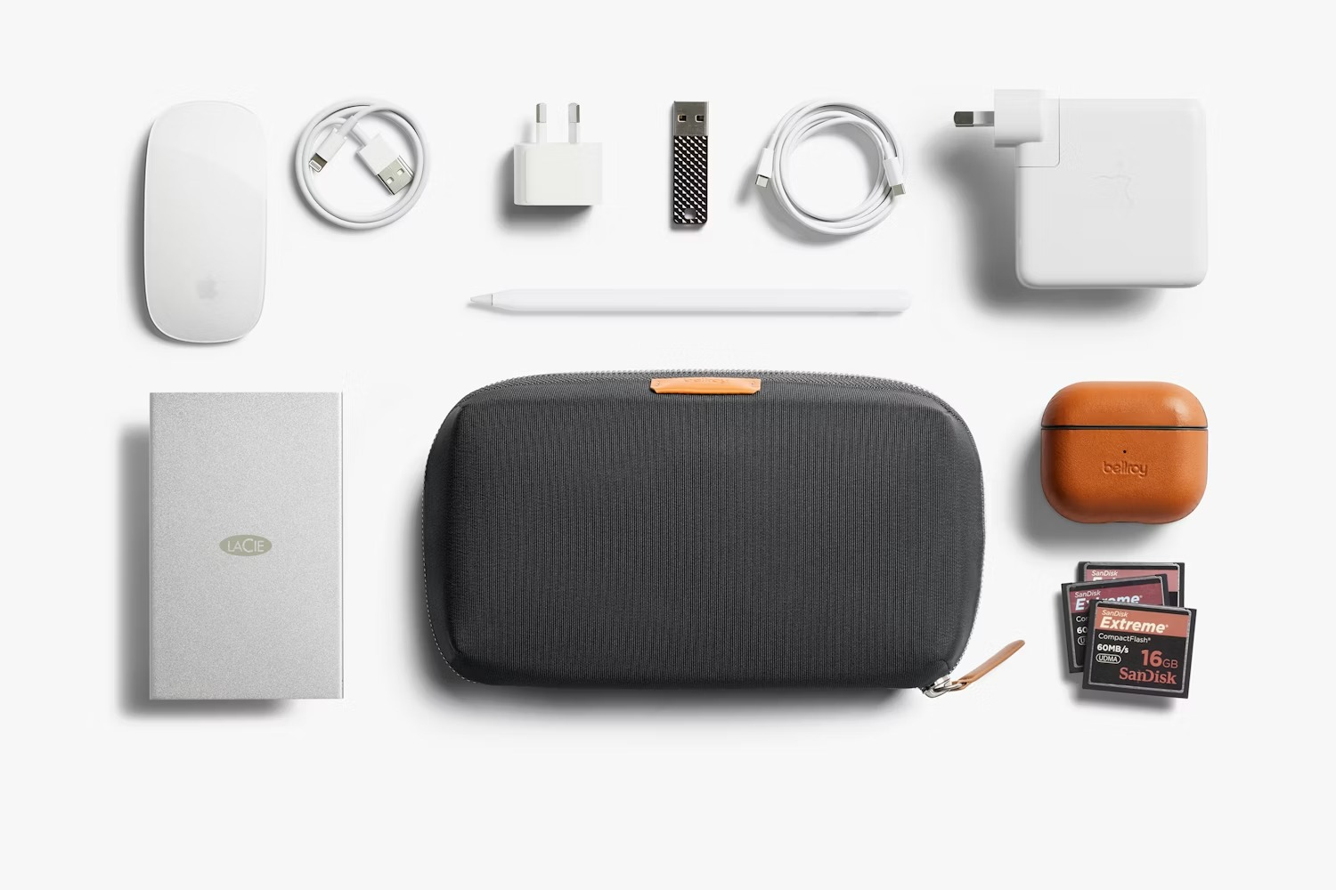 Biała mysz Apple, kable, ładowarki, Apple Pencil, dysk LaCie, etui, etui AirPods, karty SD.
