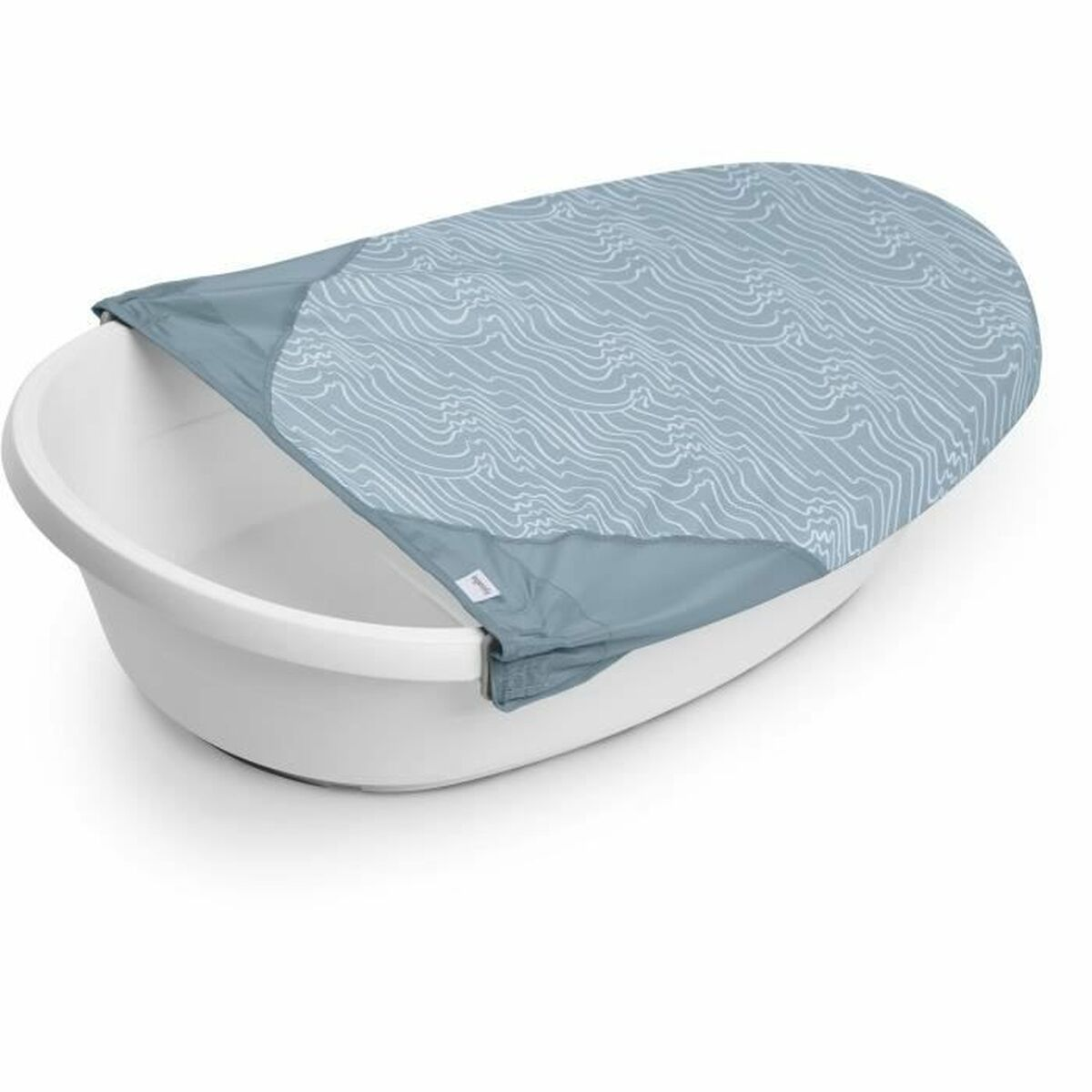 Eine weiße Babybadewanne mit einer blau gemusterten Abdeckung mit Wellenlinien.
