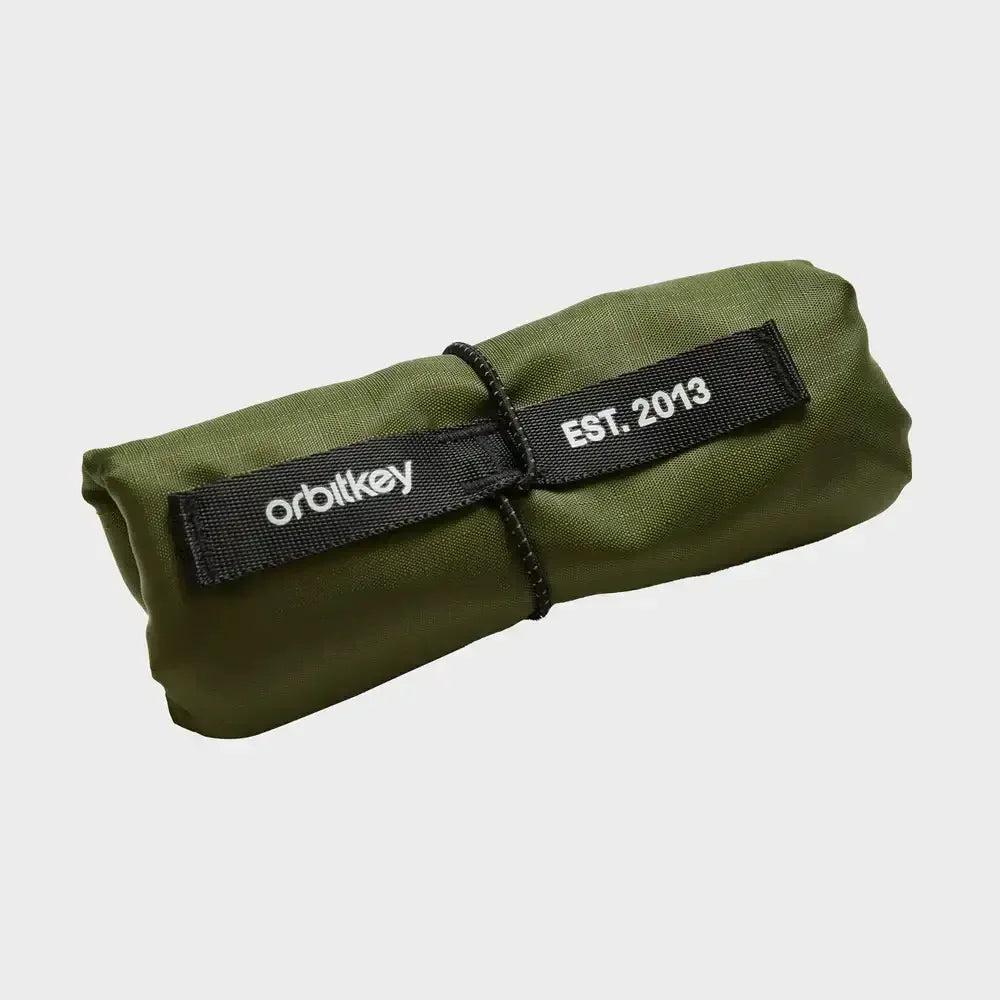 Zrolowana zielona saszetka Orbitkey zabezpieczona sznurkiem, z napisem "EST. 2013".
