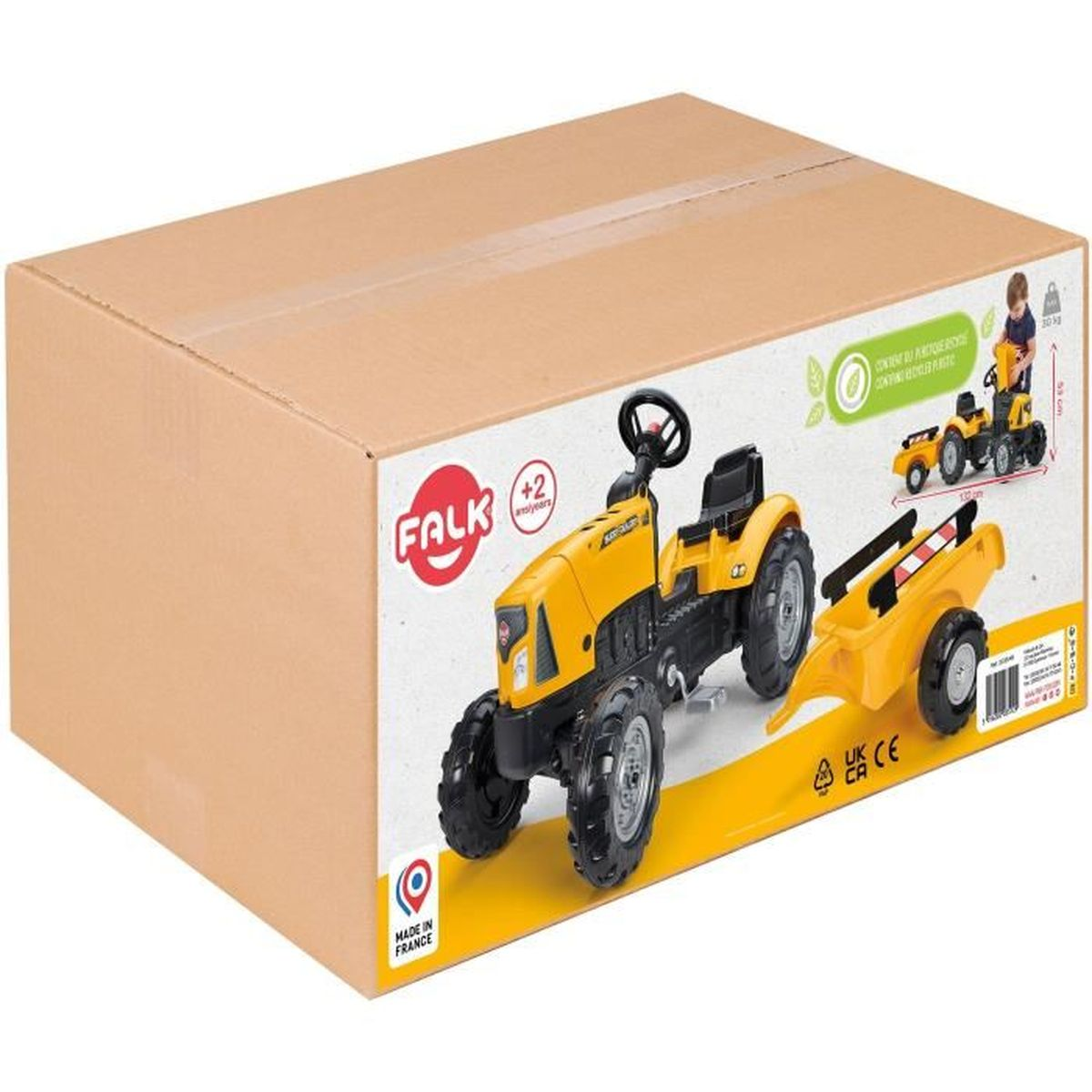 Gelber Spielzeugtraktor mit Anhänger auf einer Kartonschachtel. Alter 2+.