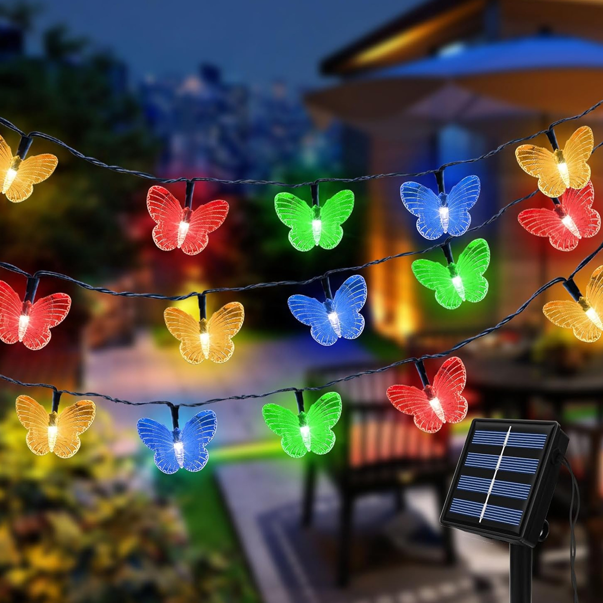 Bunte Schmetterlingslichter mit Solarpanel im Garten bei Nacht.