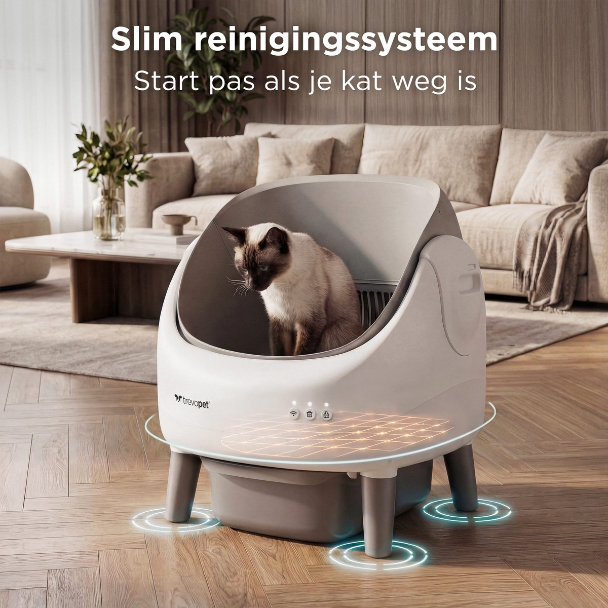 Een kat zit in een moderne, grijze kattenbak in een woonkamer.