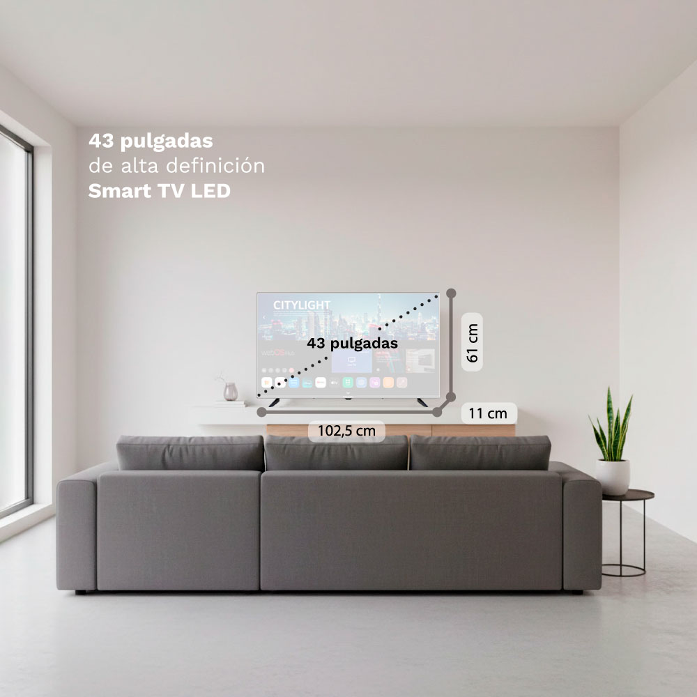 Un sofá gris frente a un televisor de pared con medidas.