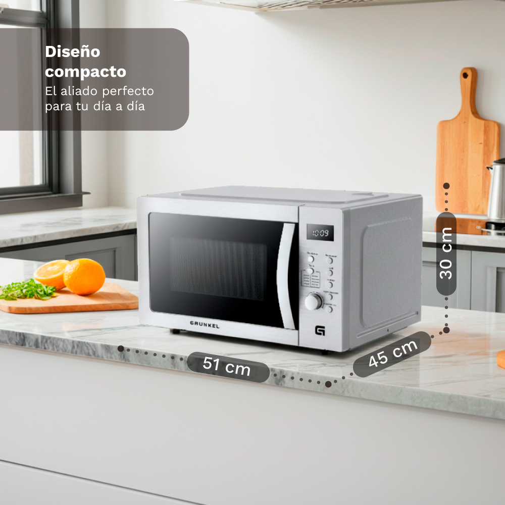 Un forno a microonde argentato su un piano di lavoro in marmo. Dimensioni indicate.