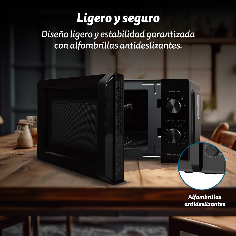 Forno a microonde nero con porta aperta su tavolo in legno.