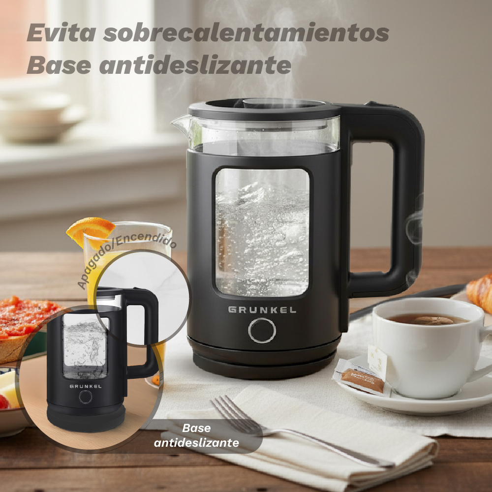 Una tetera eléctrica negra con recipiente de vidrio hierve agua sobre una mesa de madera, con una taza de té.