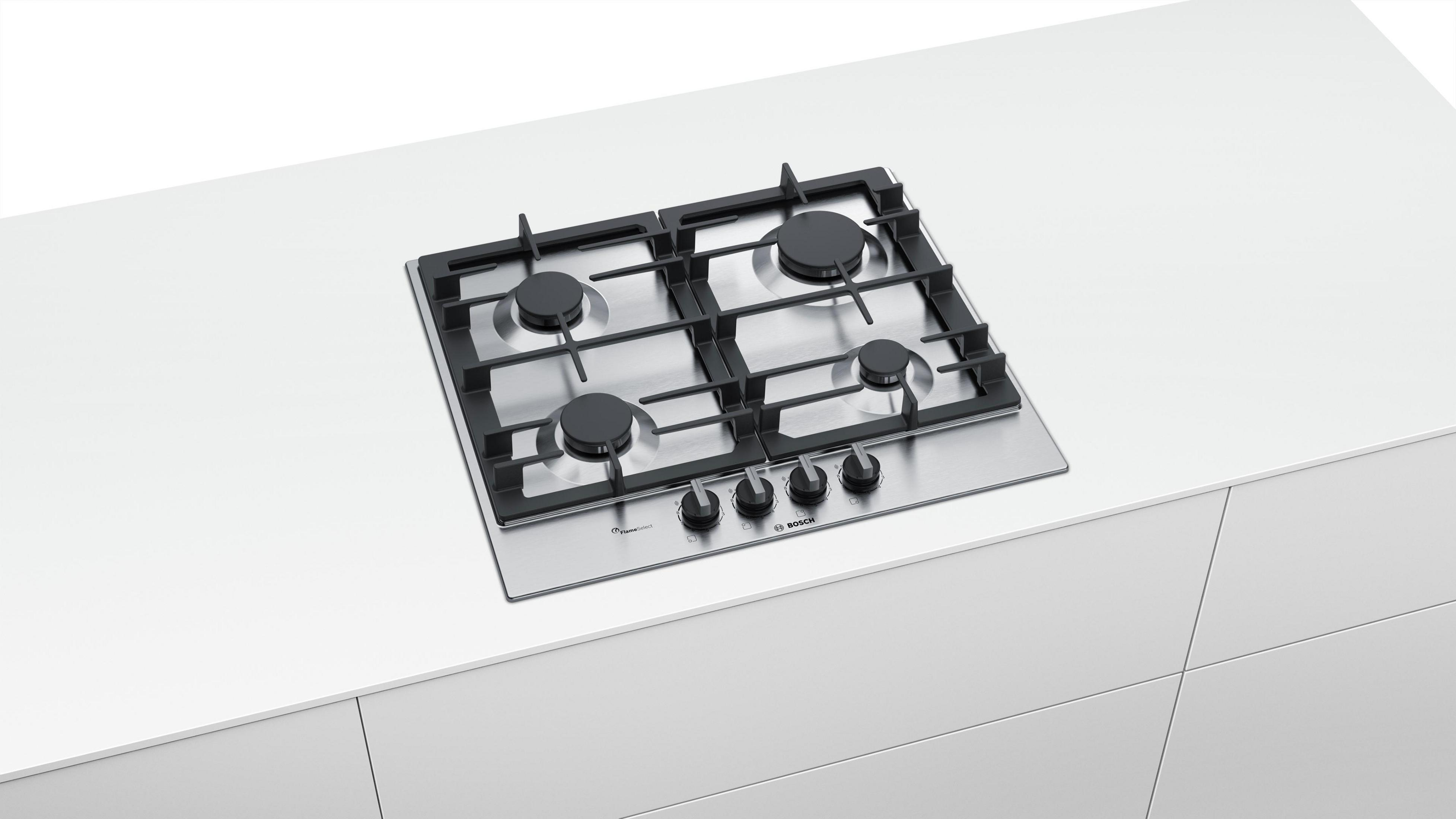 Plaque de cuisson à gaz en acier inoxydable avec quatre brûleurs sur plan de travail blanc.