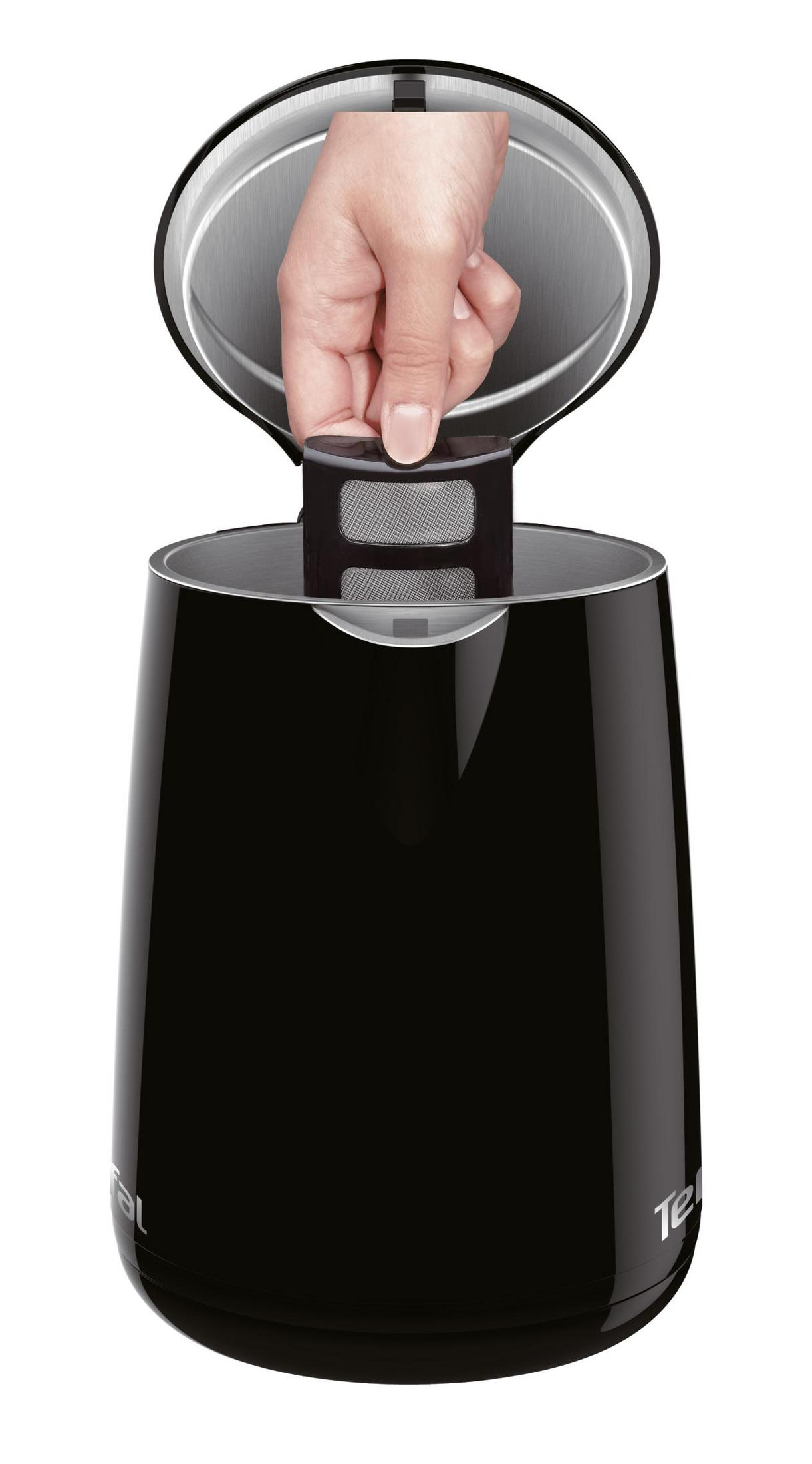 Eine Hand setzt einen schwarzen Teefilter in einen schwarzen Wasserkocher ein.