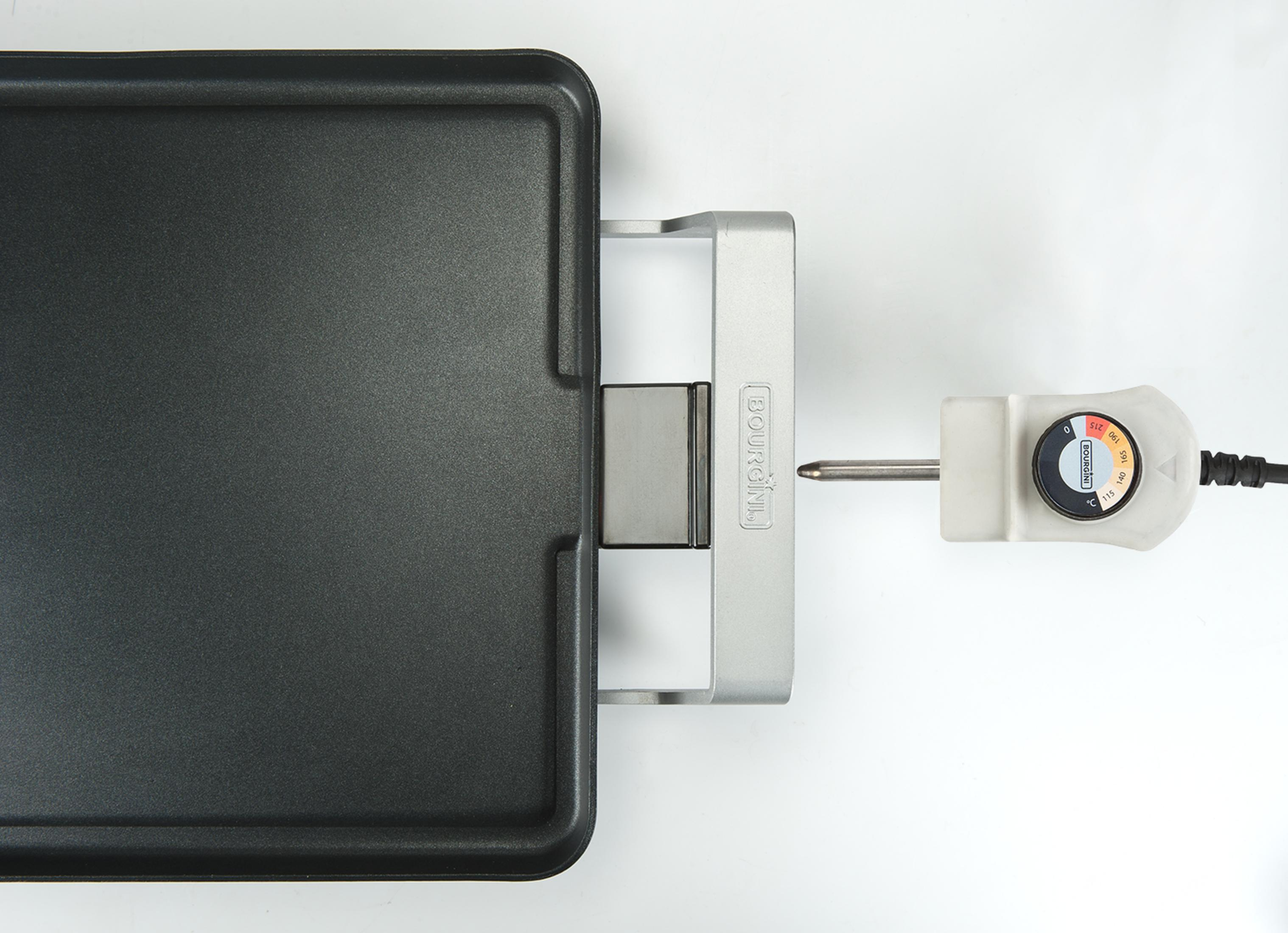 Eine elektrische Grillplatte mit silbernem Griff und Thermostatregler.