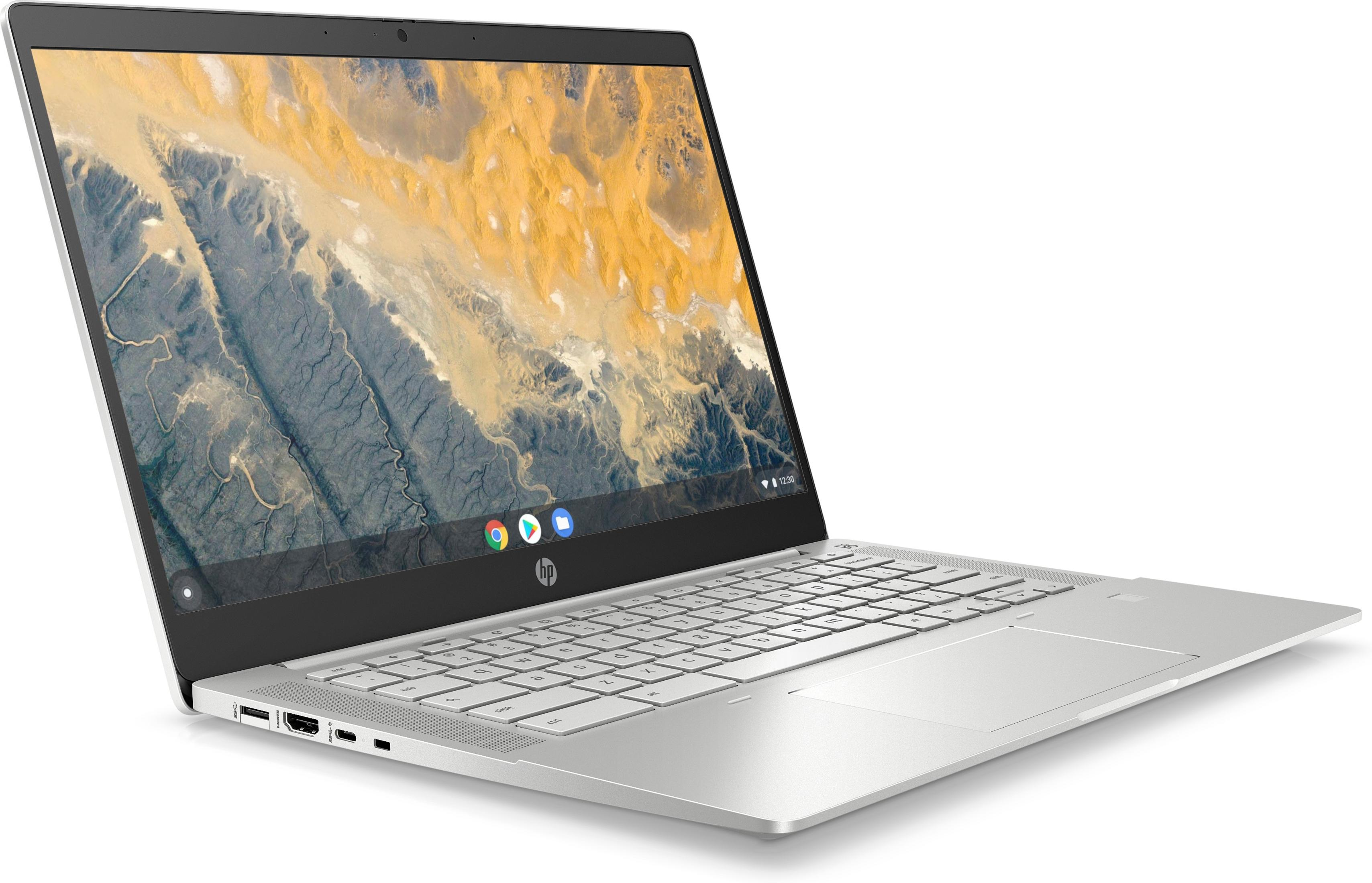 A silver laptop with its screen open, displaying a mountainous landscape.