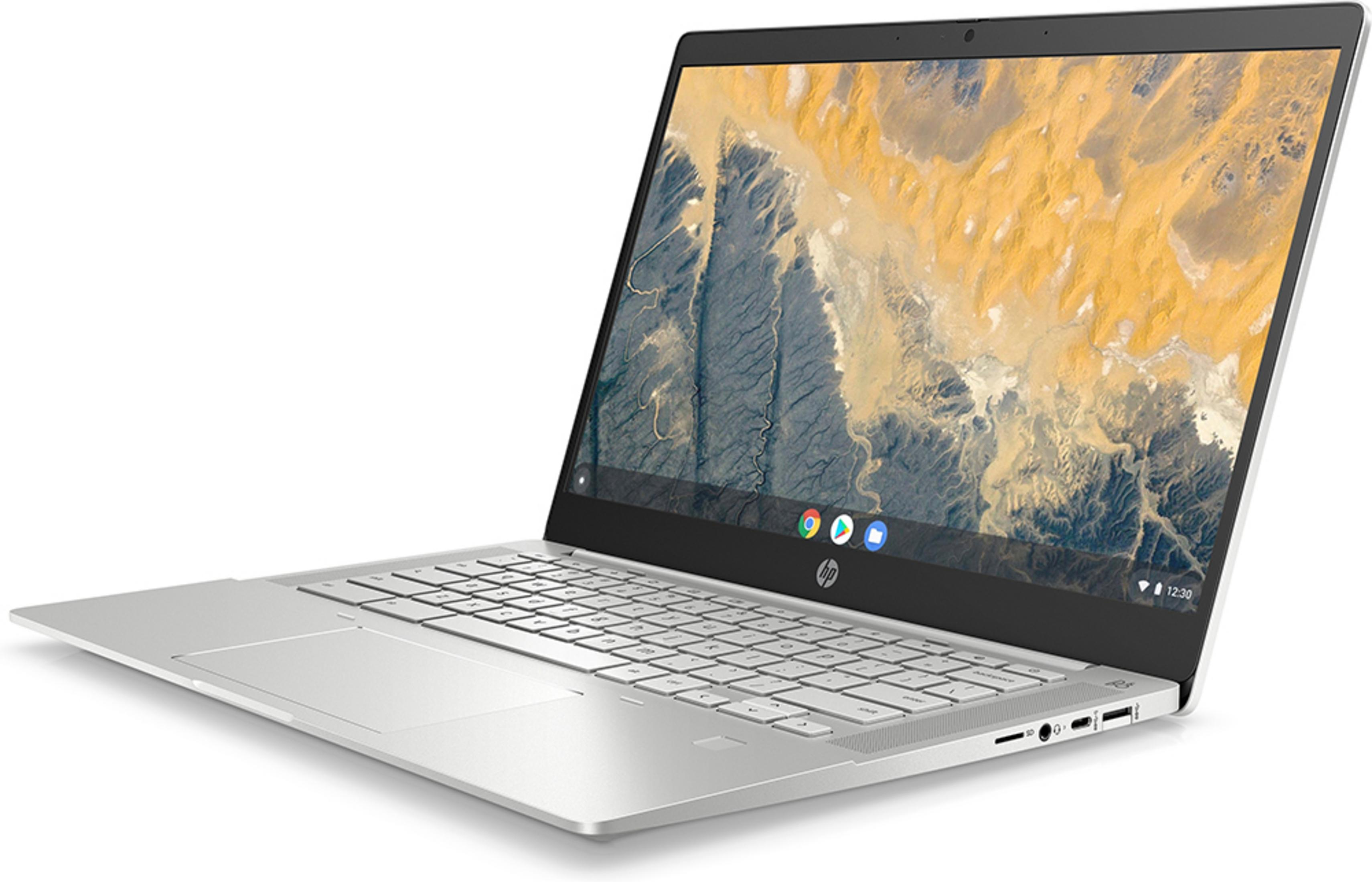 A silver laptop with its screen open, displaying a mountainous desert landscape.