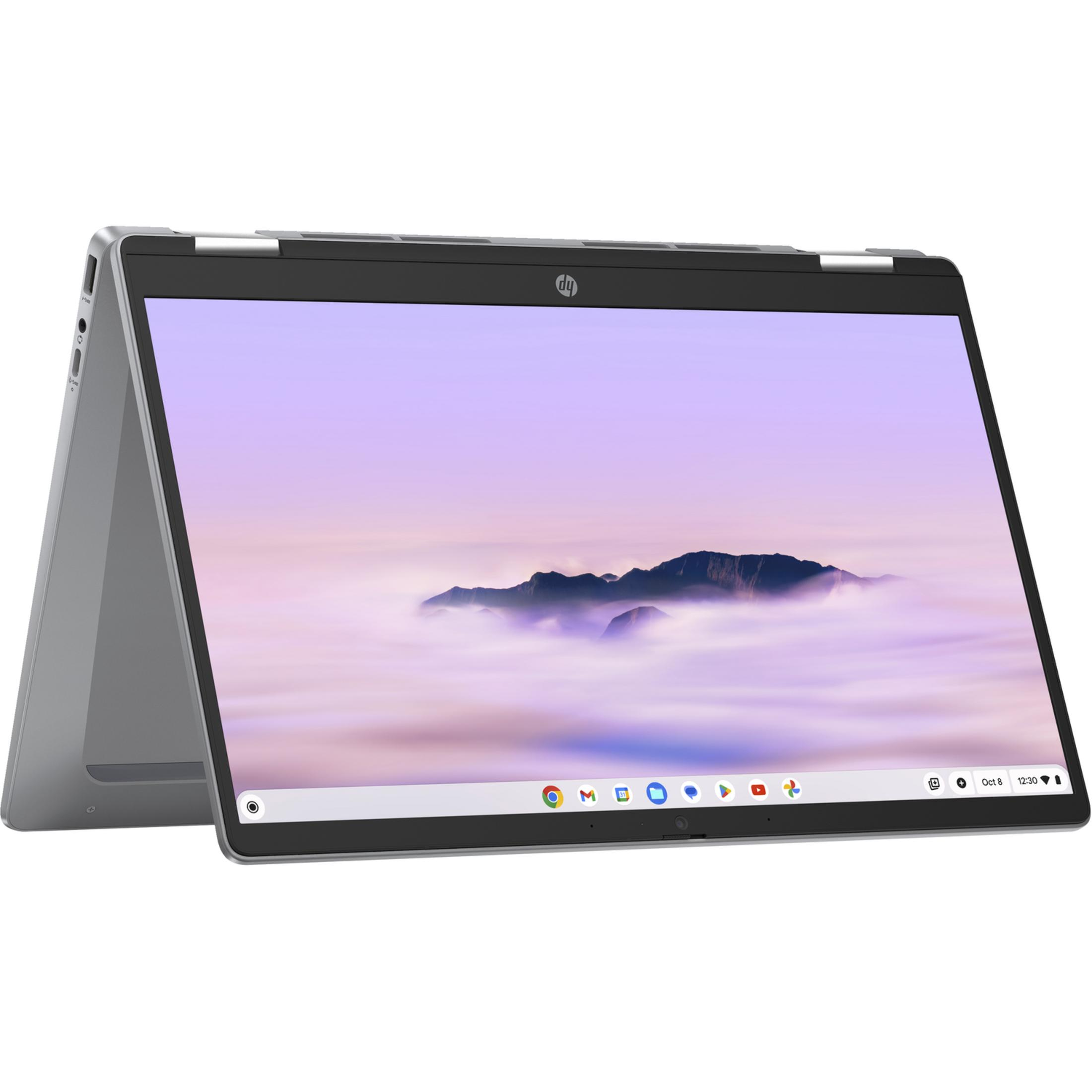 Srebrny laptop z otwartym ekranem, pokazujący górski krajobraz nad chmurami.