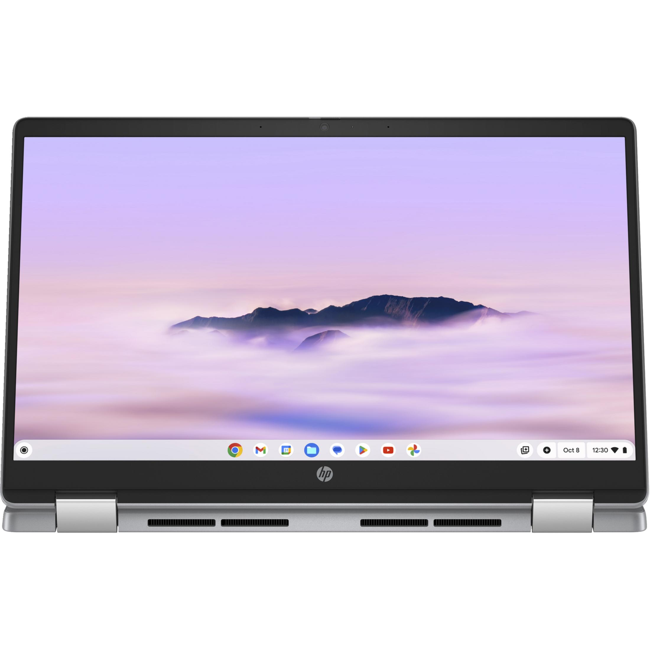 Otwarty laptop z widokiem górskiego krajobrazu we mgle na ekranie.