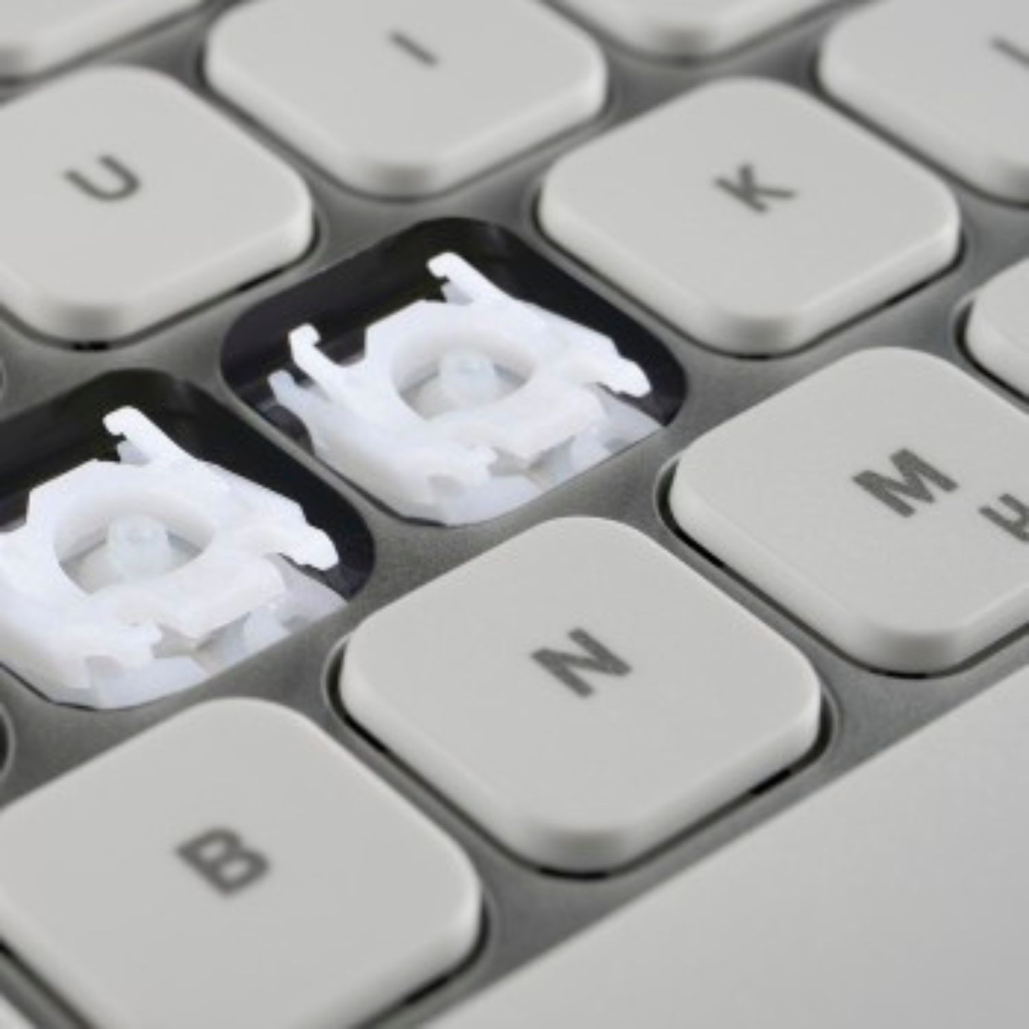 Nahaufnahme der weißen Tastaturmechanik unter fehlenden Tasten.