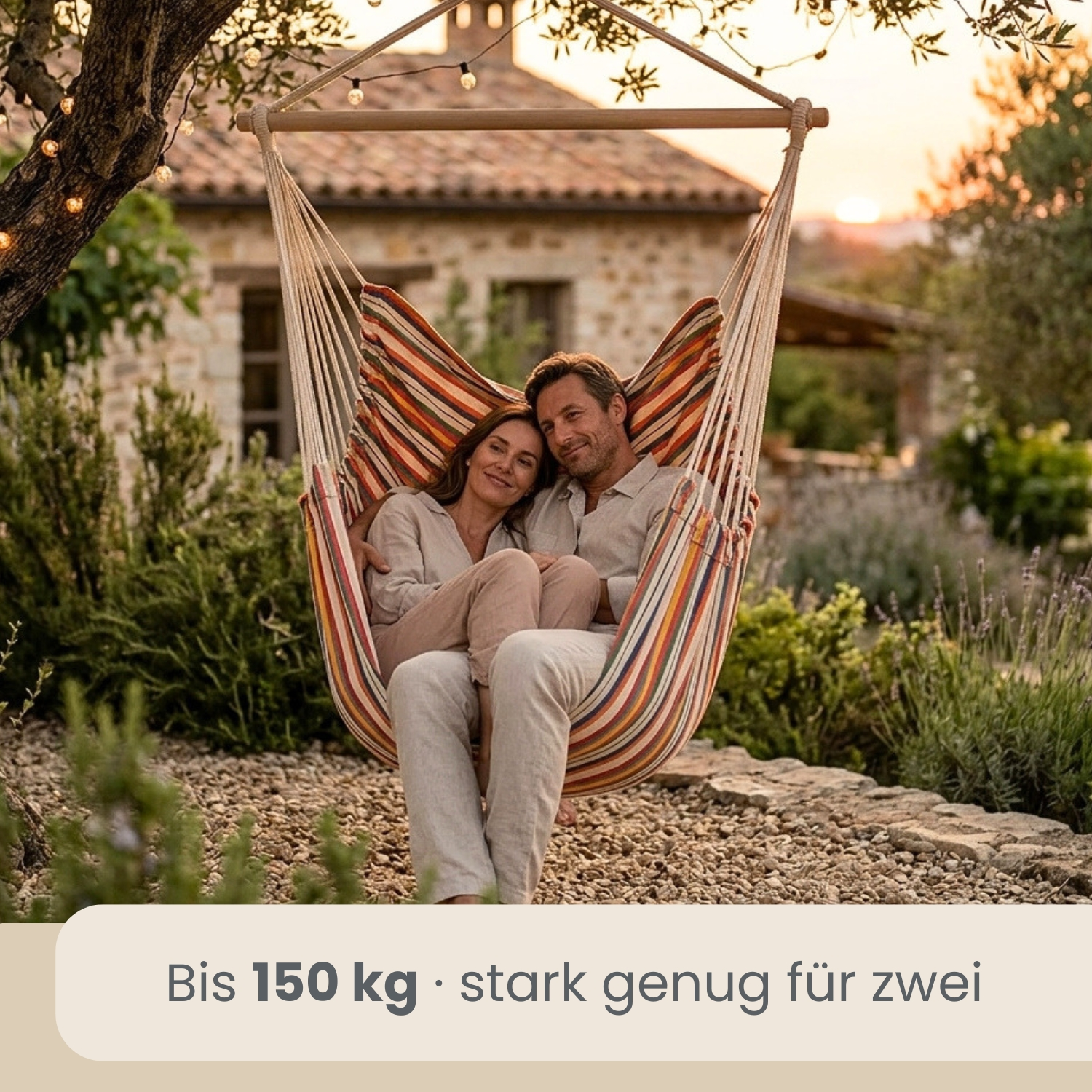 Ein Paar sitzt in einer bunten Hängeschaukel in einem Garten bei Sonnenuntergang.