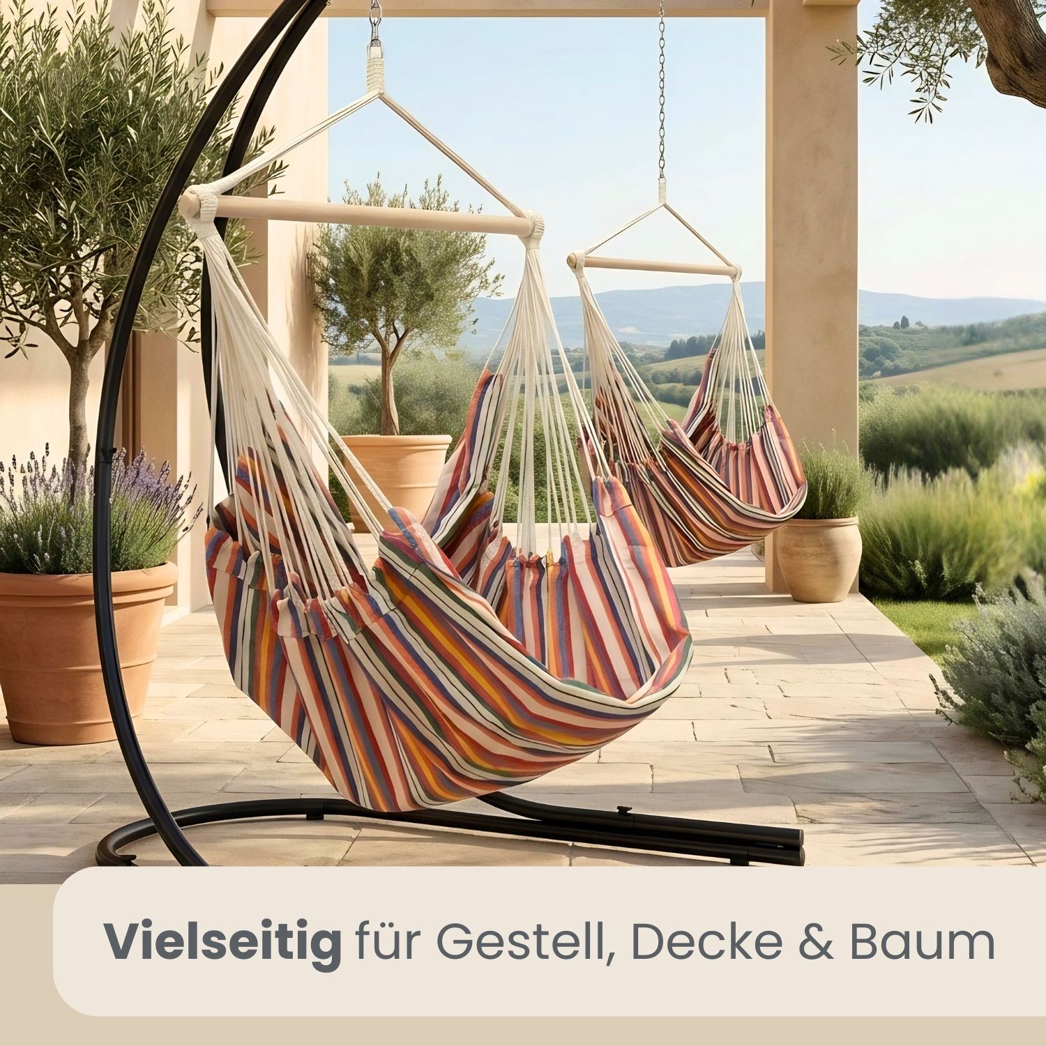 Zwei gestreifte Hängemattenstühle hängen an schwarzen Ständern auf einer gefliesten Terrasse mit Olivenbäumen.