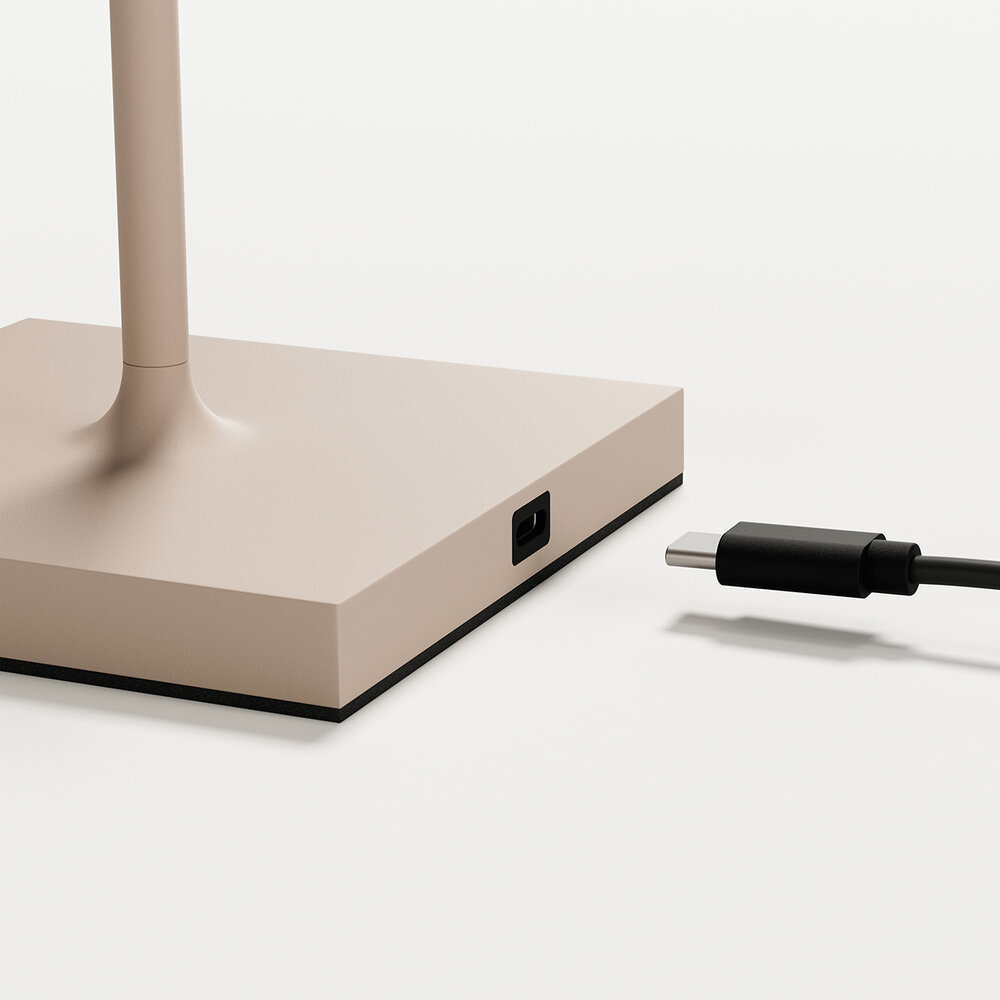 Ein beigefarbener Lampensockel mit einem USB-C-Anschluss und einem Kabel.
