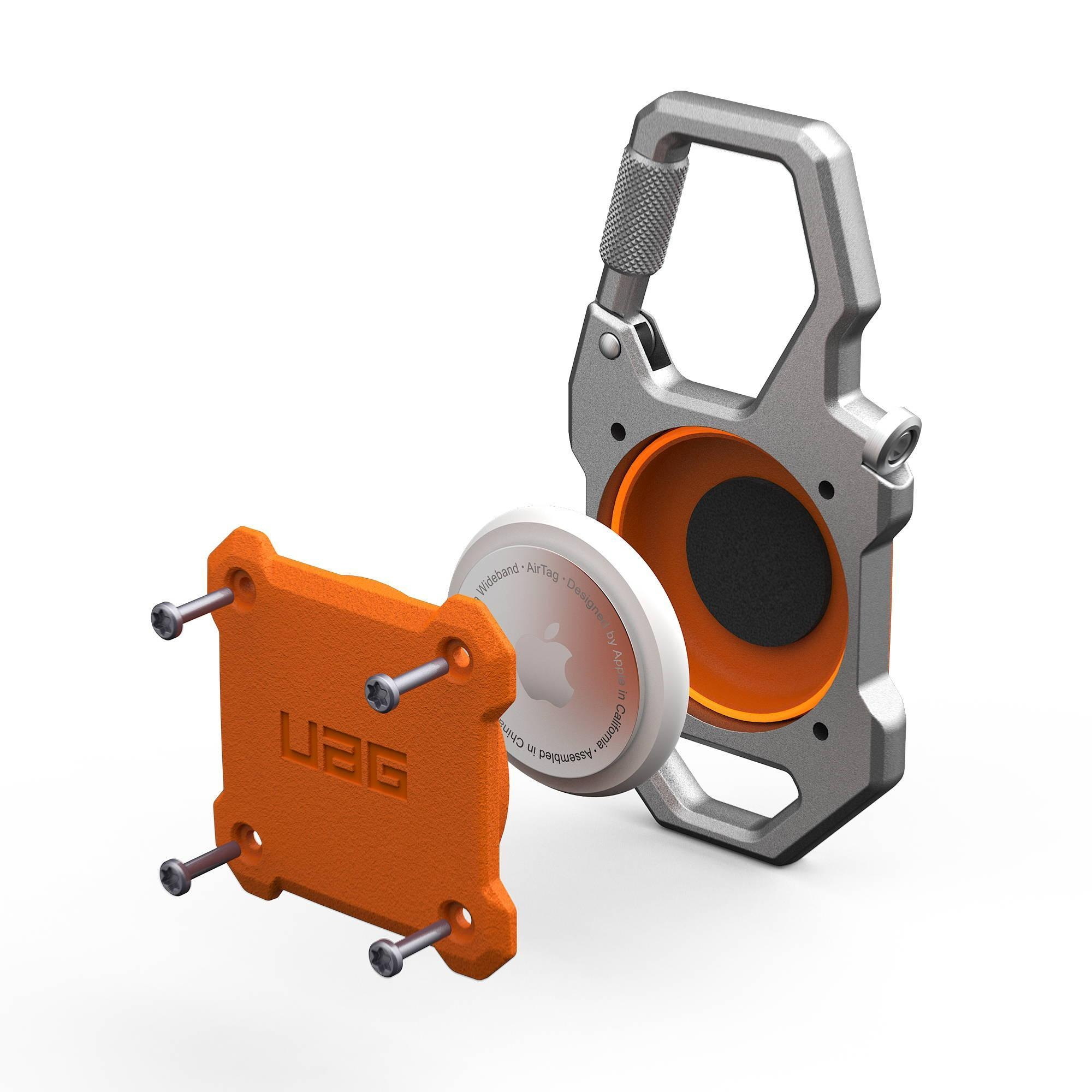 Ein silberner Karabiner hält einen orangefarbenen UAG AirTag-Halter mit Schrauben und einem AirTag.