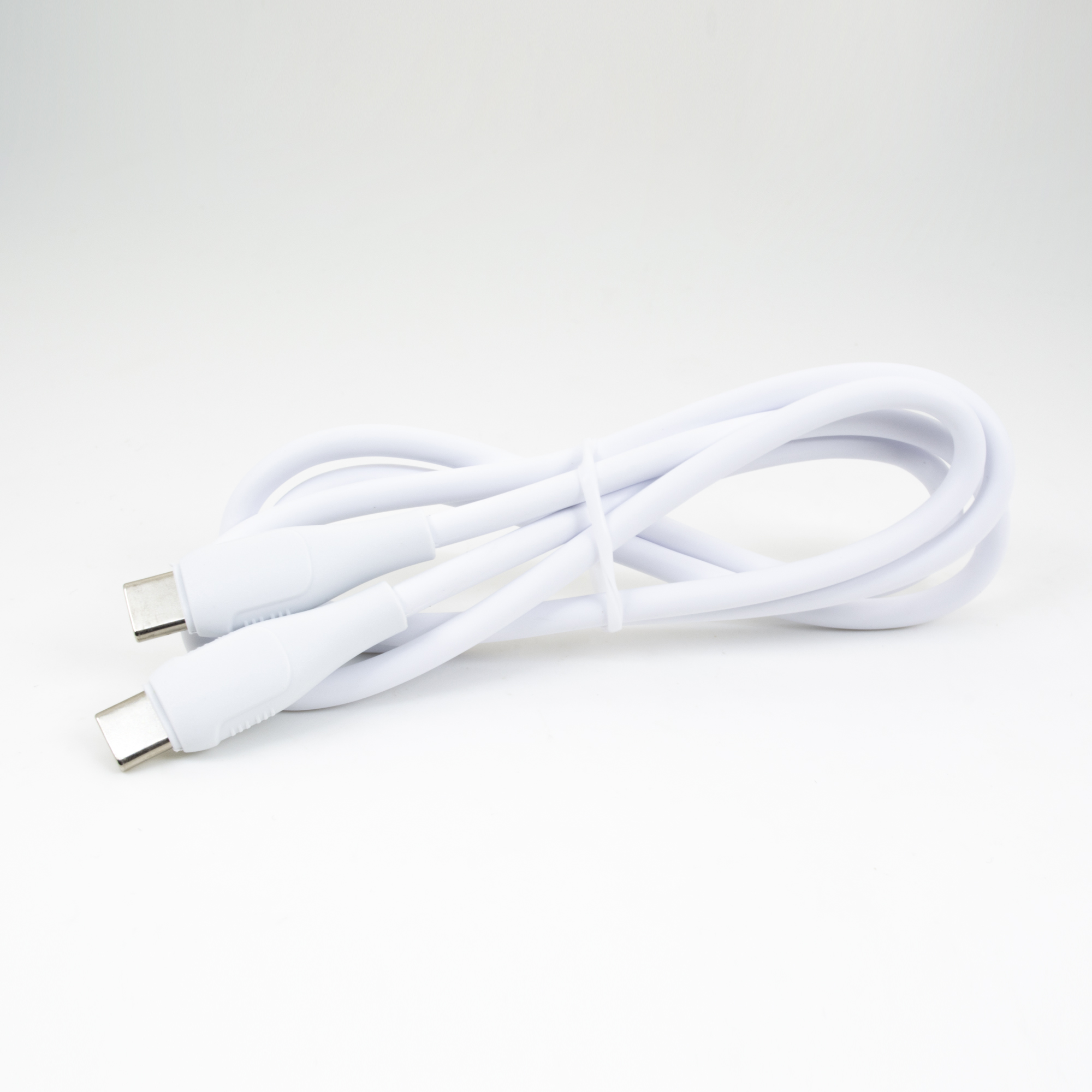 Gümüş konnektörlü beyaz bir USB-C kablosu beyaz zeminde sarılıdır.