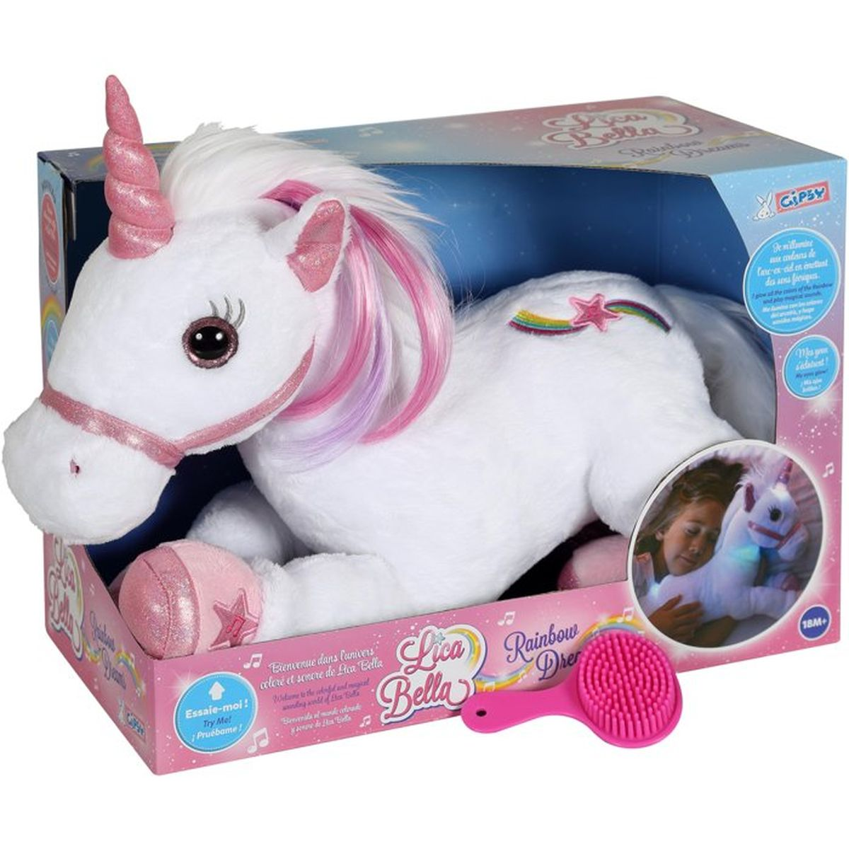 Un unicornio de peluche blanco con crin y cuerno rosas yace en una caja con cepillo.