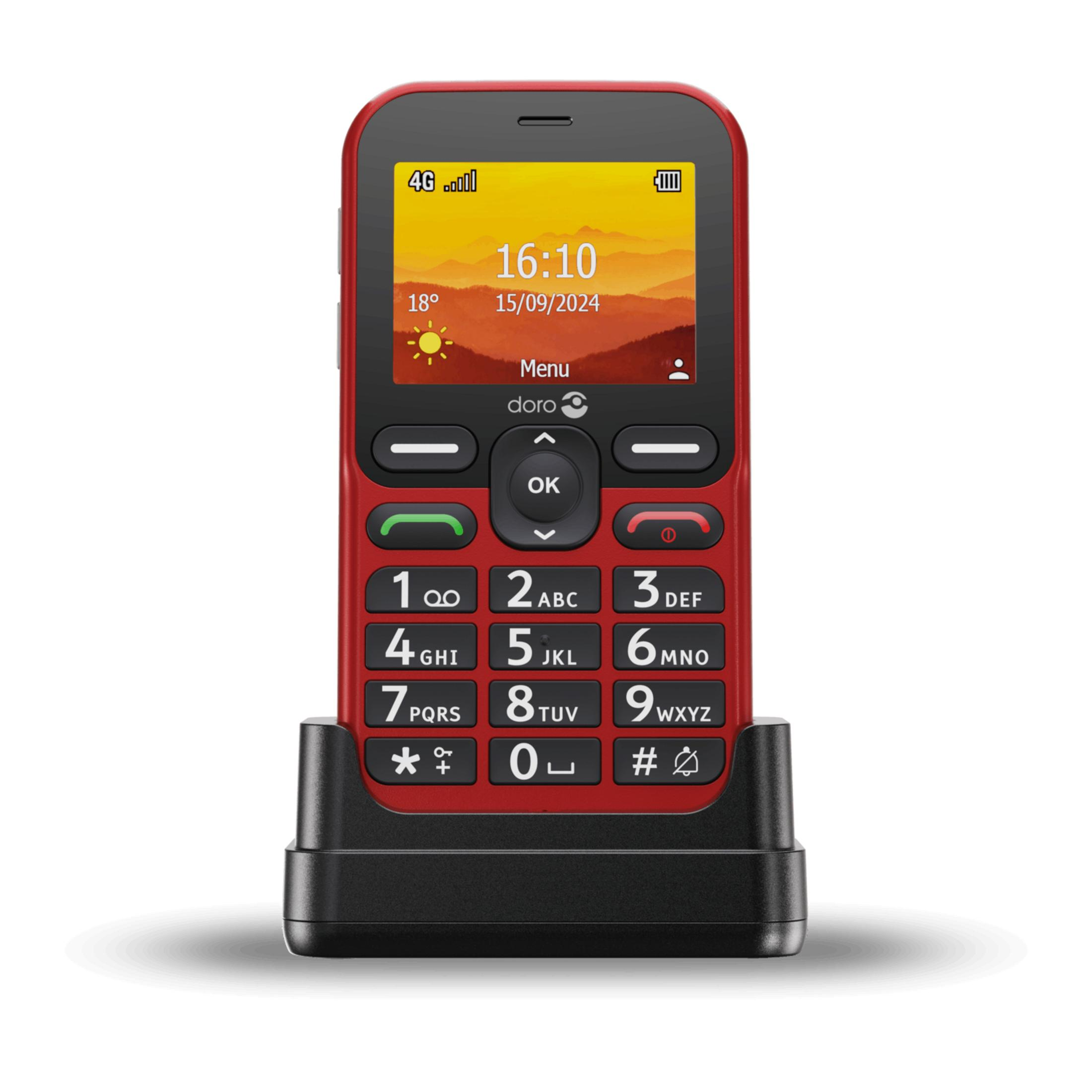 Czerwony telefon komórkowy Doro z klawiaturą i stacją ładującą. Ekran pokazuje czas.
