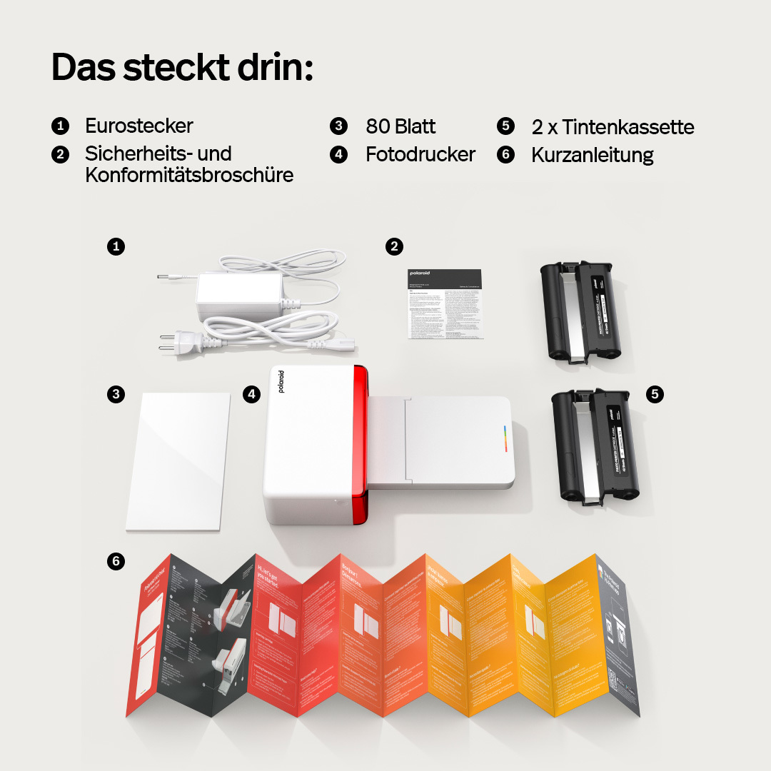 Zestaw drukarki Polaroid z akcesoriami: zasilacz, instrukcja, drukarka, tusz i papier.