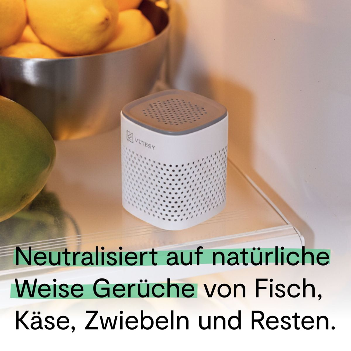 Ein weißer Geruchsneutralisierer steht neben Zitrusfrüchten in einem Kühlschrank.